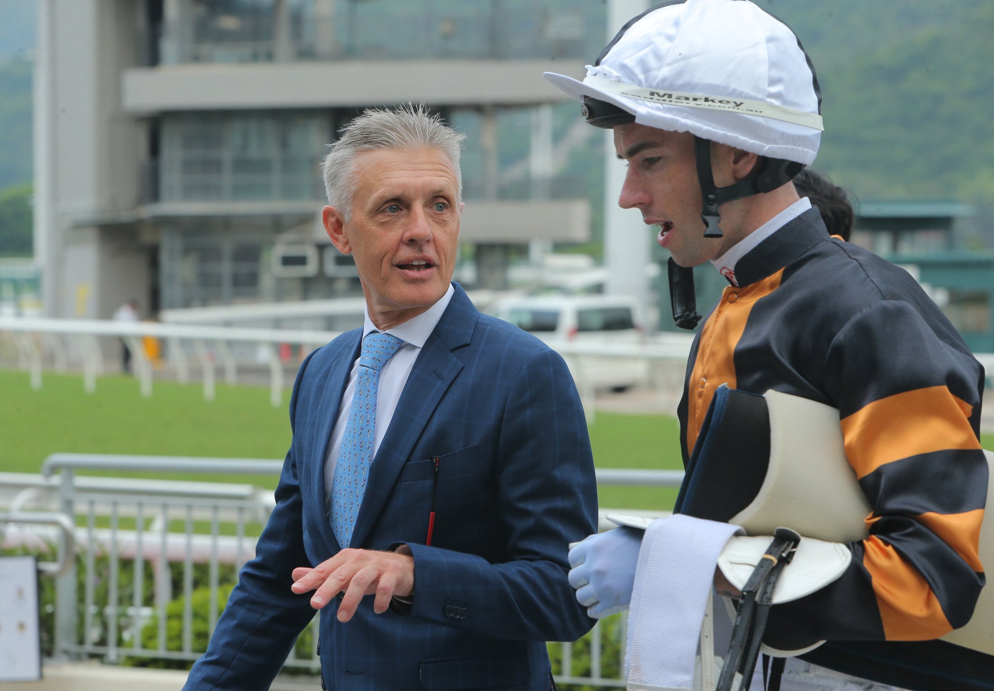 Mark Newnham debriefs with James Orman after a Sha Tin winner. Mark Newnham debriefs with James Orman after a Sha Tin winner.