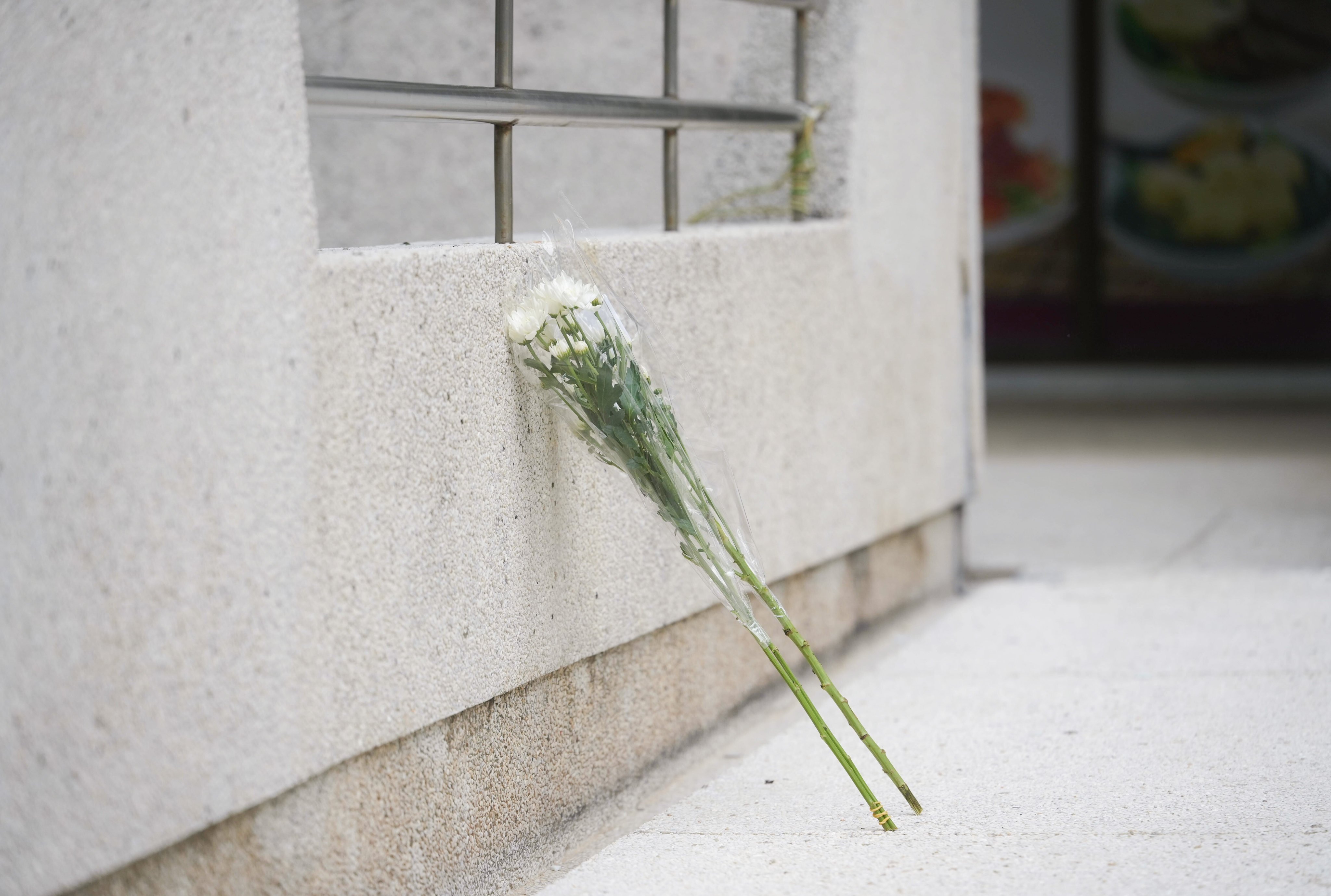 Flowers are placed outside Lu Shan Mansion, Taikoo Shing, where the girl and her mother took their own lives. Photo: Sun Yeung
