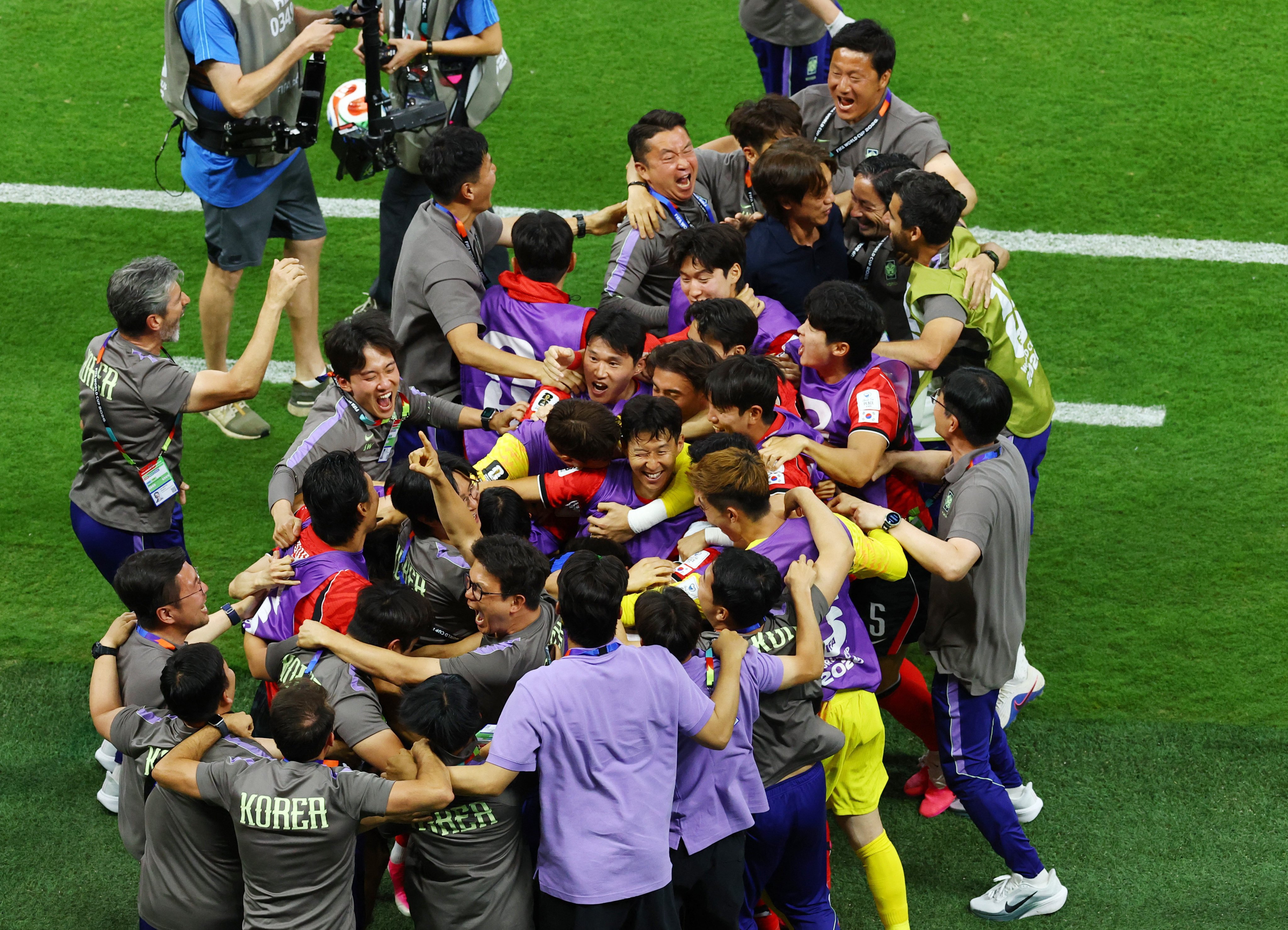 South Korea coach Hong Myung-bo (in dark blue shirt) and captain Son Heung-min (middle, winking) celebrate with the whole squad after their win over the Czech Republic. Photo: Reuters