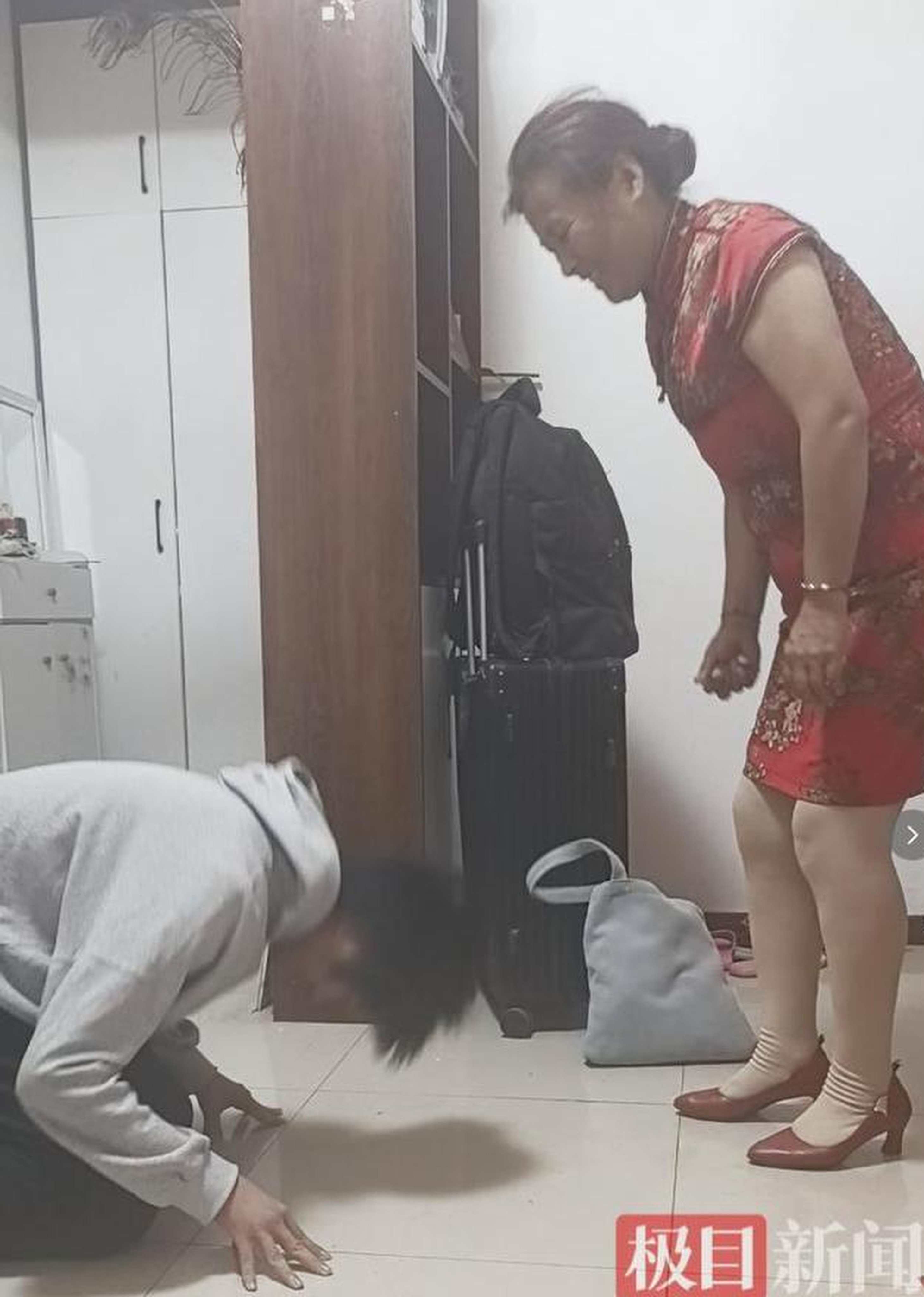 An 18-year-old boy in China, abandoned at birth and with a hearing impairment, knelt in gratitude to his adoptive mother after finishing the gaokao. Photo: Jimu News
