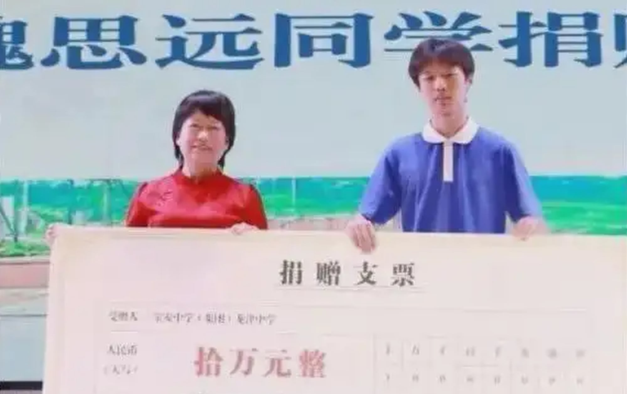 Wei, right, holds a giant mocked-up cheque showing the amount he donated to sanitation workers. Photo: Baidu Wei, right, holds a giant mocked-up cheque showing the amount he donated to sanitation workers. Photo: Baidu