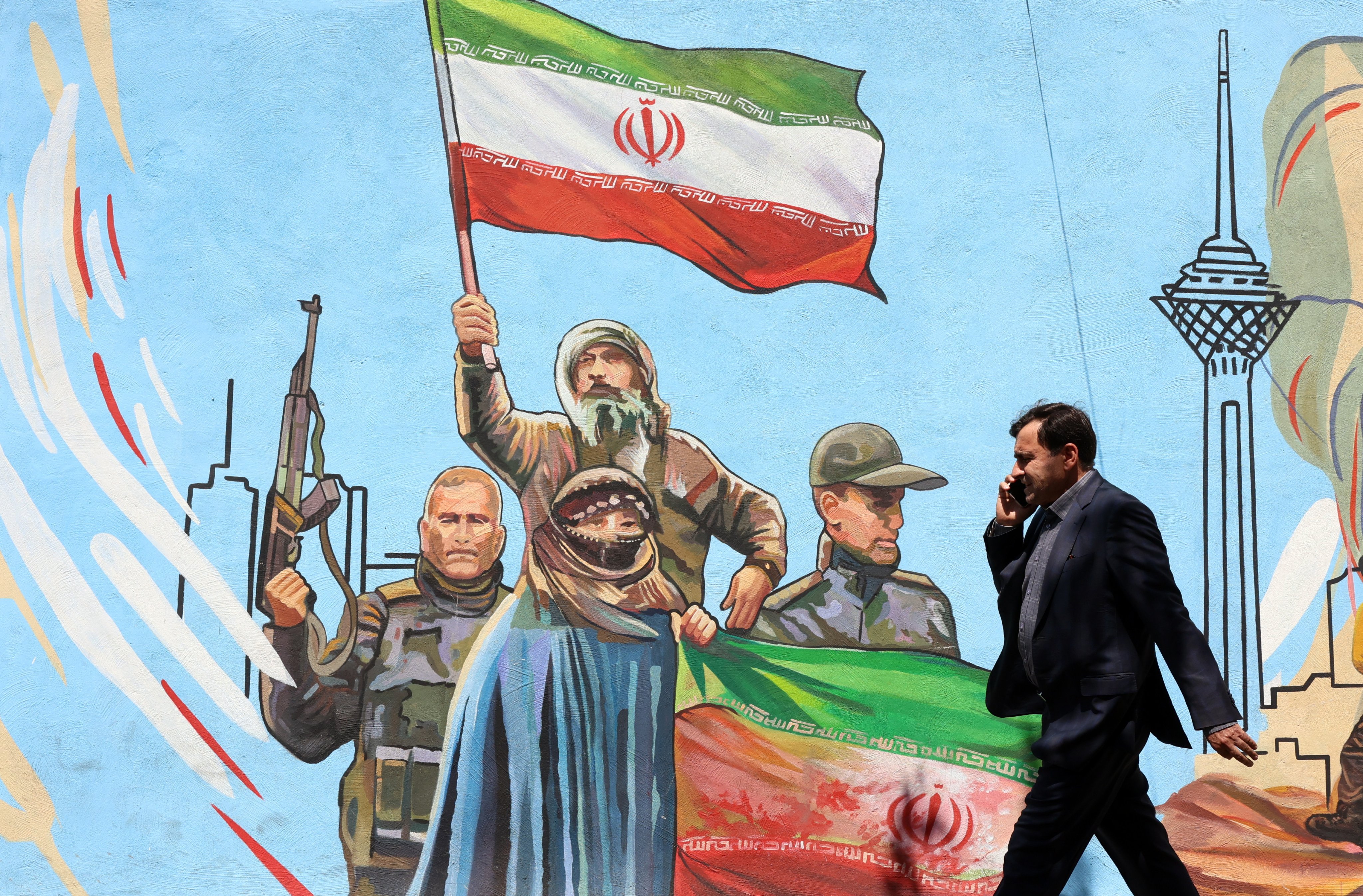 An Iranian man walks past a mural on a street in Tehran, Iran, on June 8. Photo: EPA