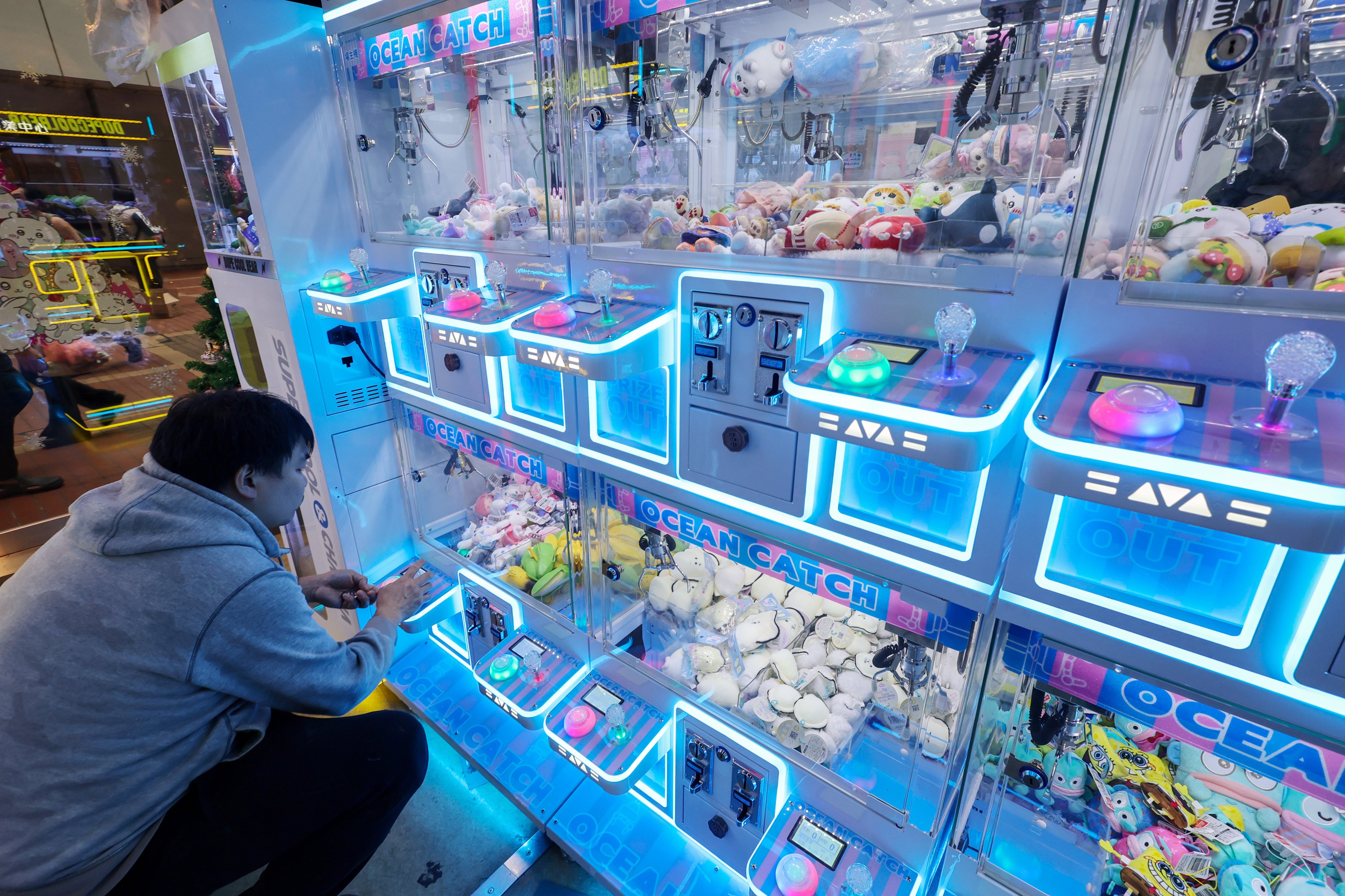 A patron tries his luck at a claw machine outlet in Mong Kok. Photo: Dickson Lee