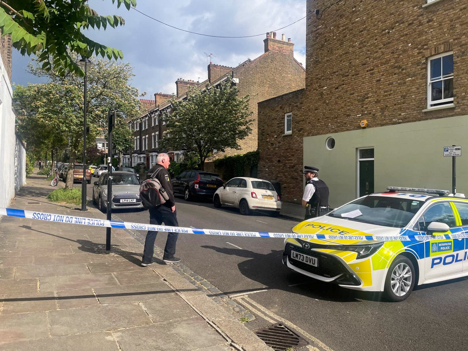 A person walks to a police officer at a cordoned off street, where a fire broke out at Britain’s Prime Minister Keir Starmer’s home in May 2025. Photo: Reuters
