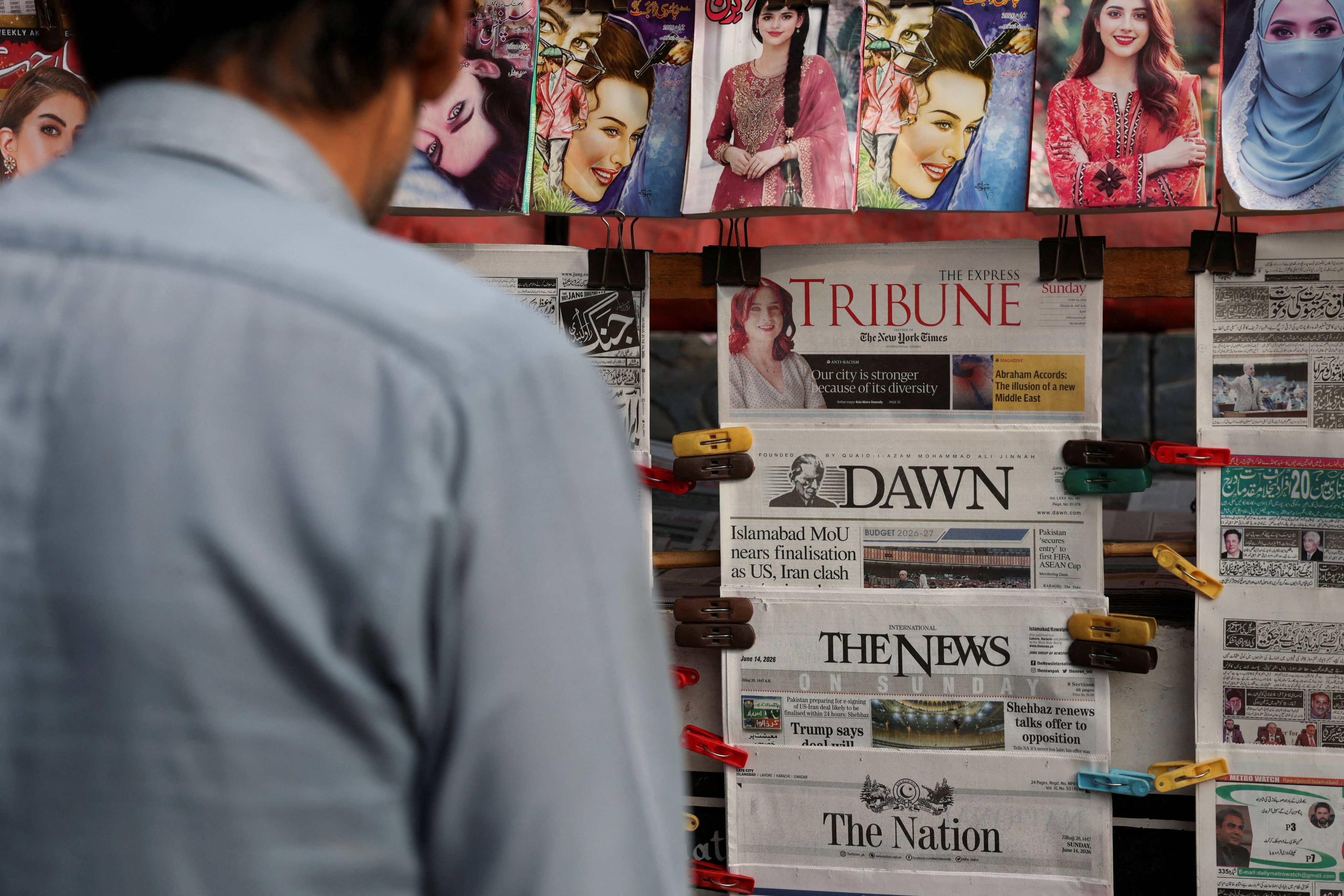 A man stops at a newsstand in Islamabad, Pakistan on Sunday, ahead of the expected US-Iran peace deal signing. Photo: Reuters