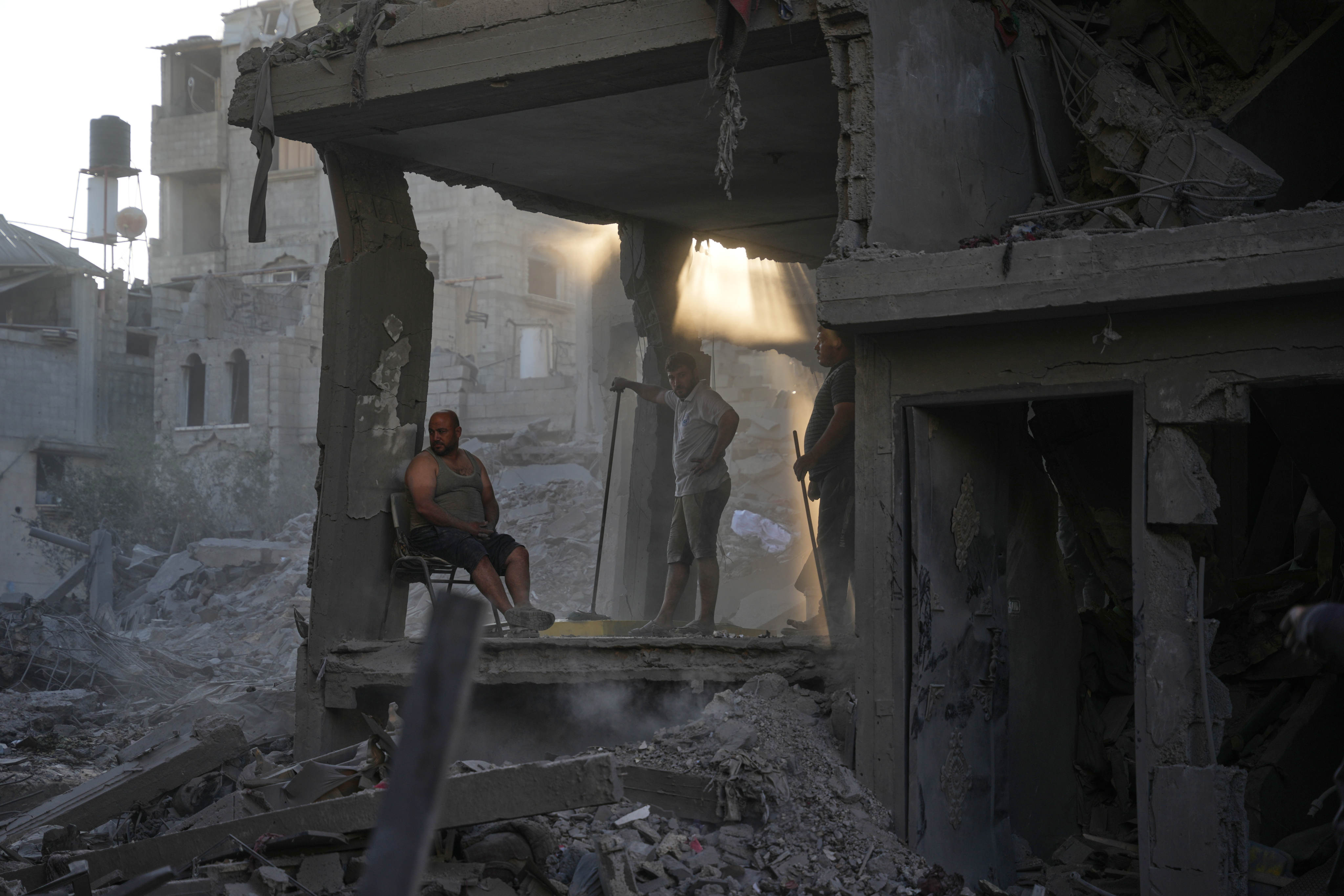 Palestinians clear the rubble of a building that was destroyed in an Israeli airstrike at Al-Maghazi refugee camp in central Gaza Strip on Friday. Photo: AP