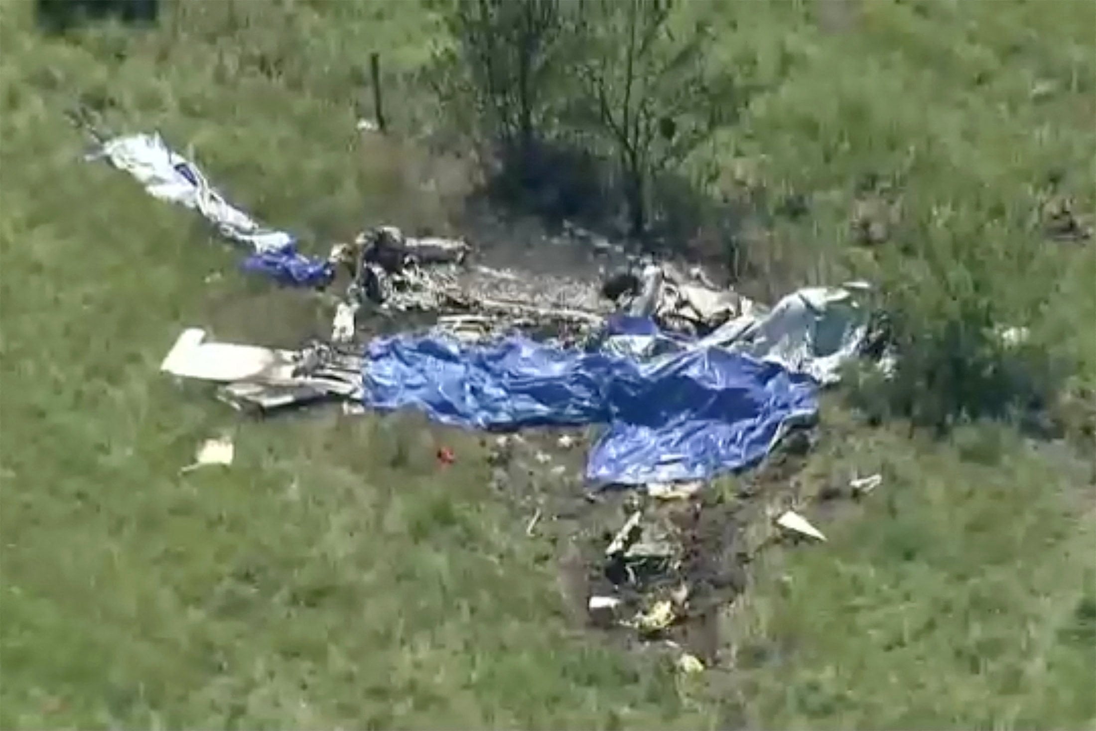 Wreckage lies in a field next to Butler Memorial Airport in Missouri after a plane carrying skydivers crashed on Sunday. Photo: ABC Affiliate KMBC via Reuters