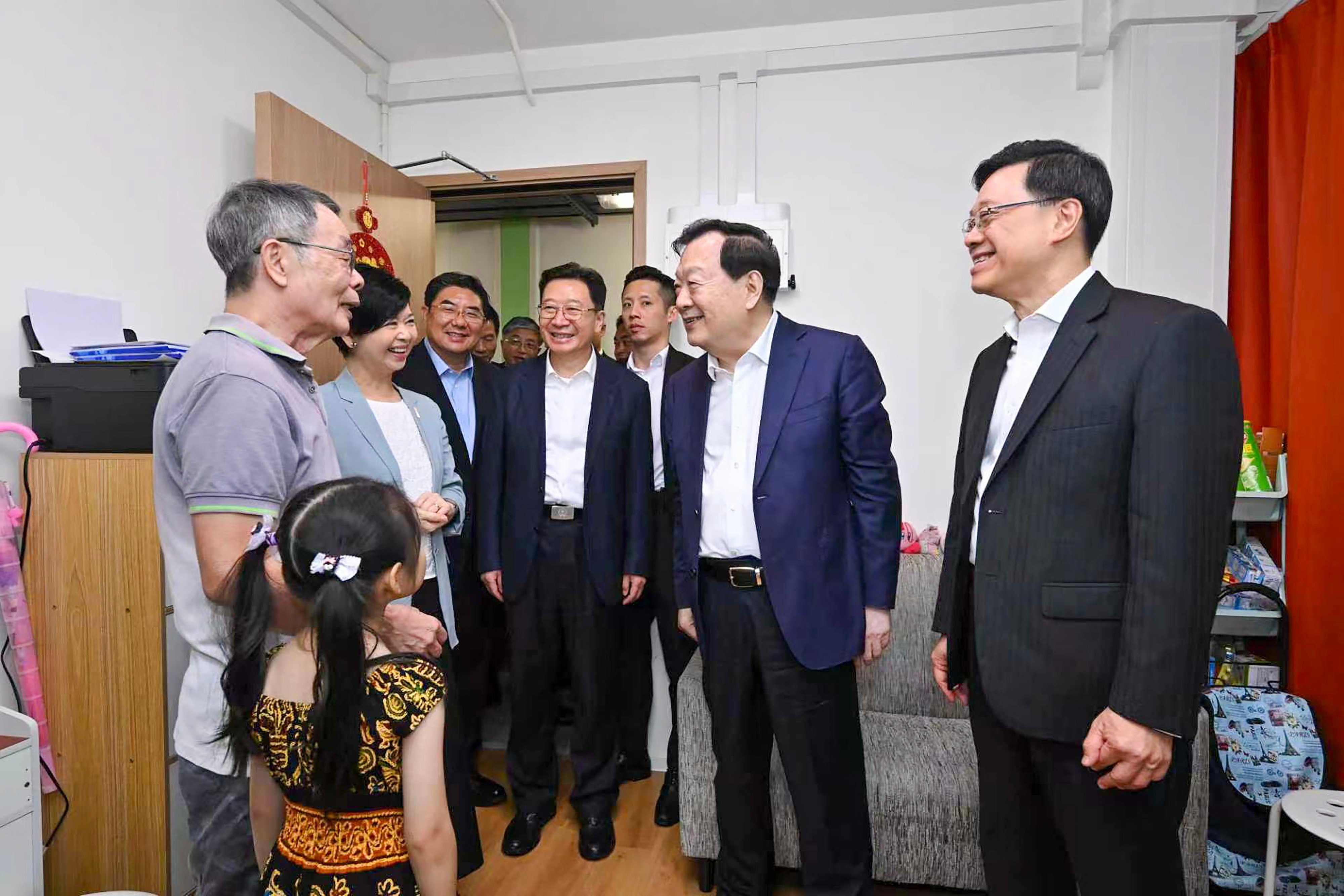 Xia Baolong (second right), with John Lee (right) and other officials, greets residents at a light public housing project in Yuen Long. Photo: Handout
