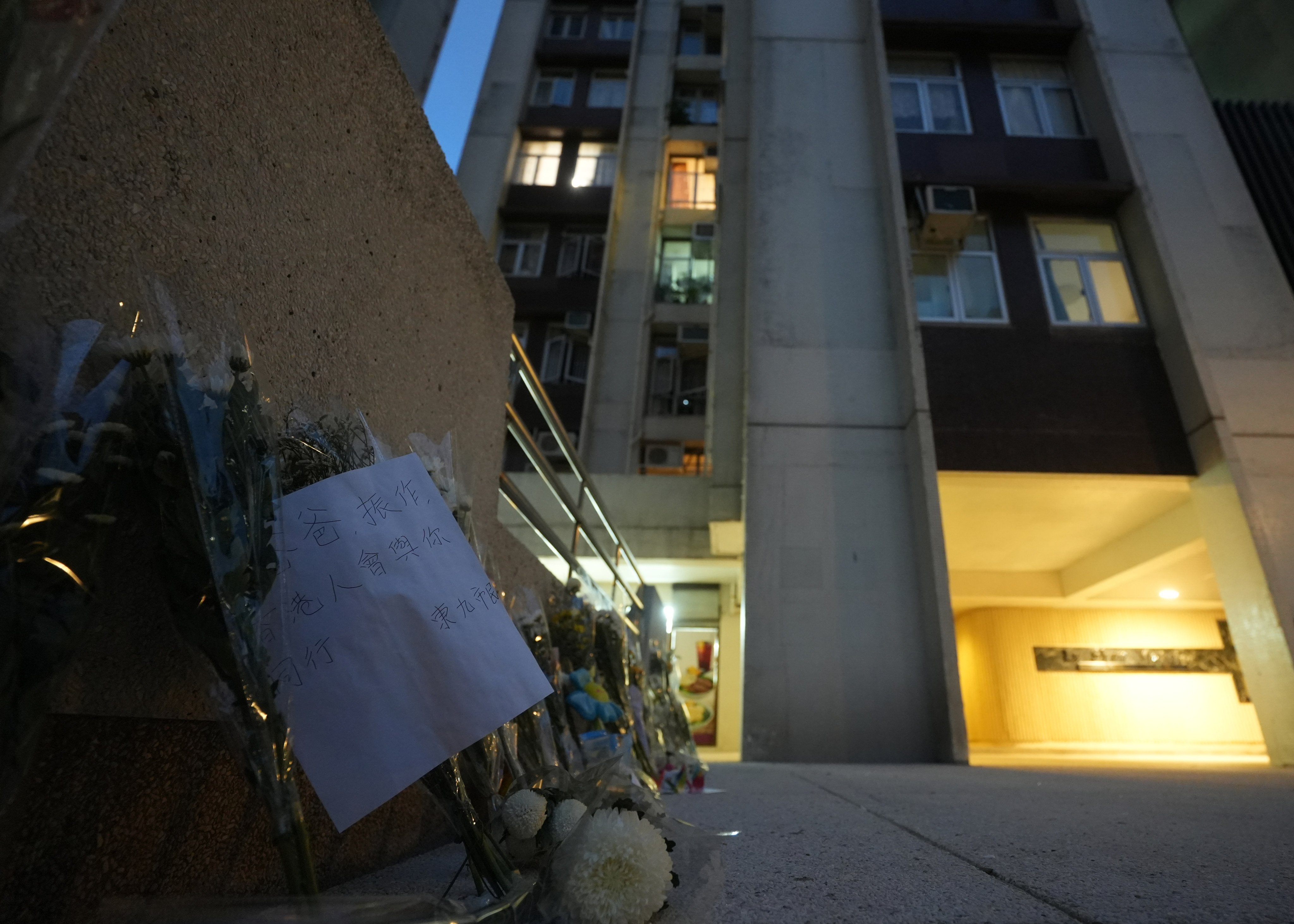 Flowers are left outside Lu Shan Mansion, Taikoo Shing, where a 48-year-old mother and 12-year-old daughter fell from same flat hours apart last week. Photo: Sun Yeung