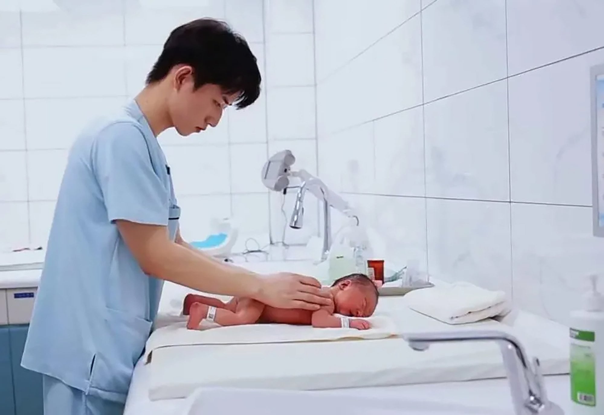 Zhang, above, deals tenderly with a newborn child in hospital. Photo: Weixin Zhang, above, deals tenderly with a newborn child in hospital. Photo: Weixin