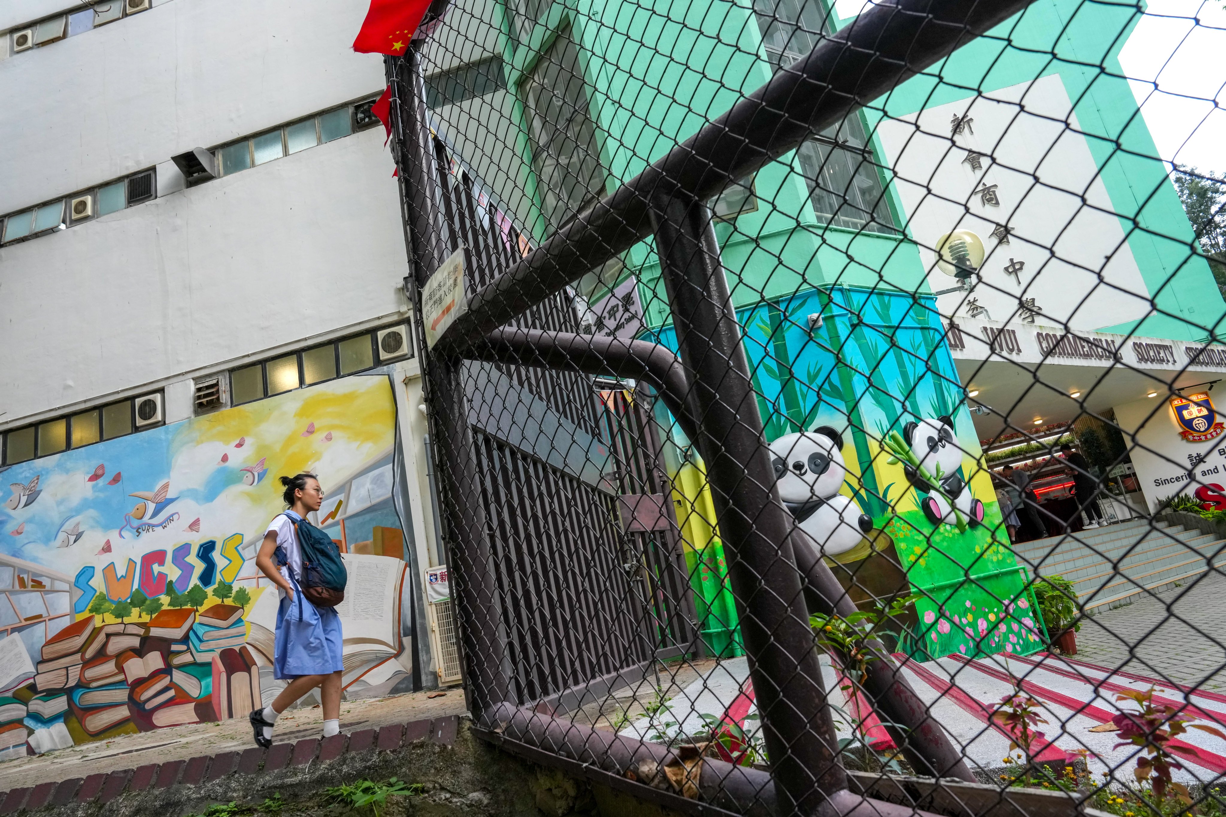 A student walking into the San Wui Commercial Society Secondary School in Tuen Mun on May 29. The school has fired its principal after he swore at security guards during a student trip to Singapore last month. Jelly Tse