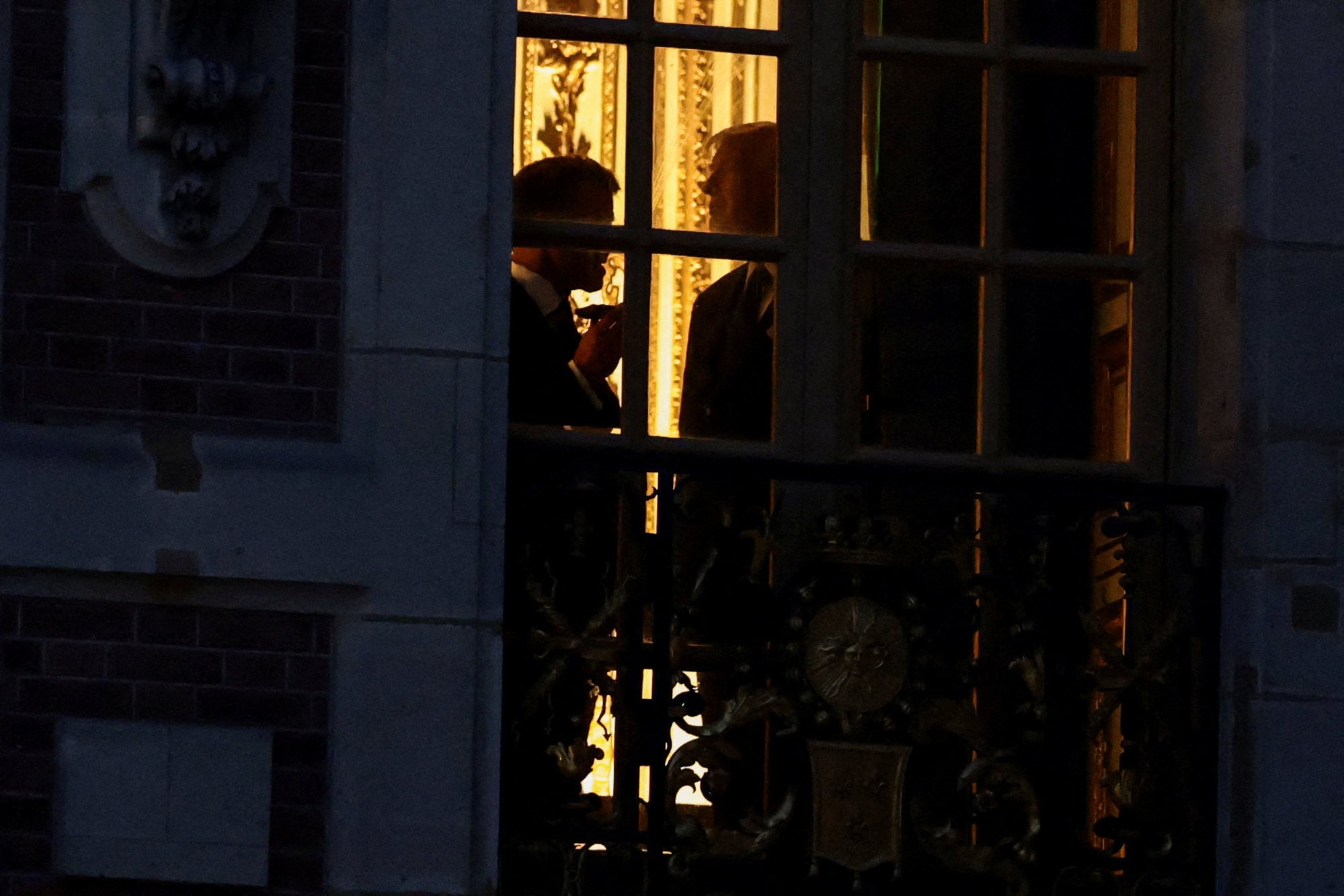 French President Emmanuel Macron and US President Donald Trump, as seen near a window at the Palace of Versailles. Photo: Reuters