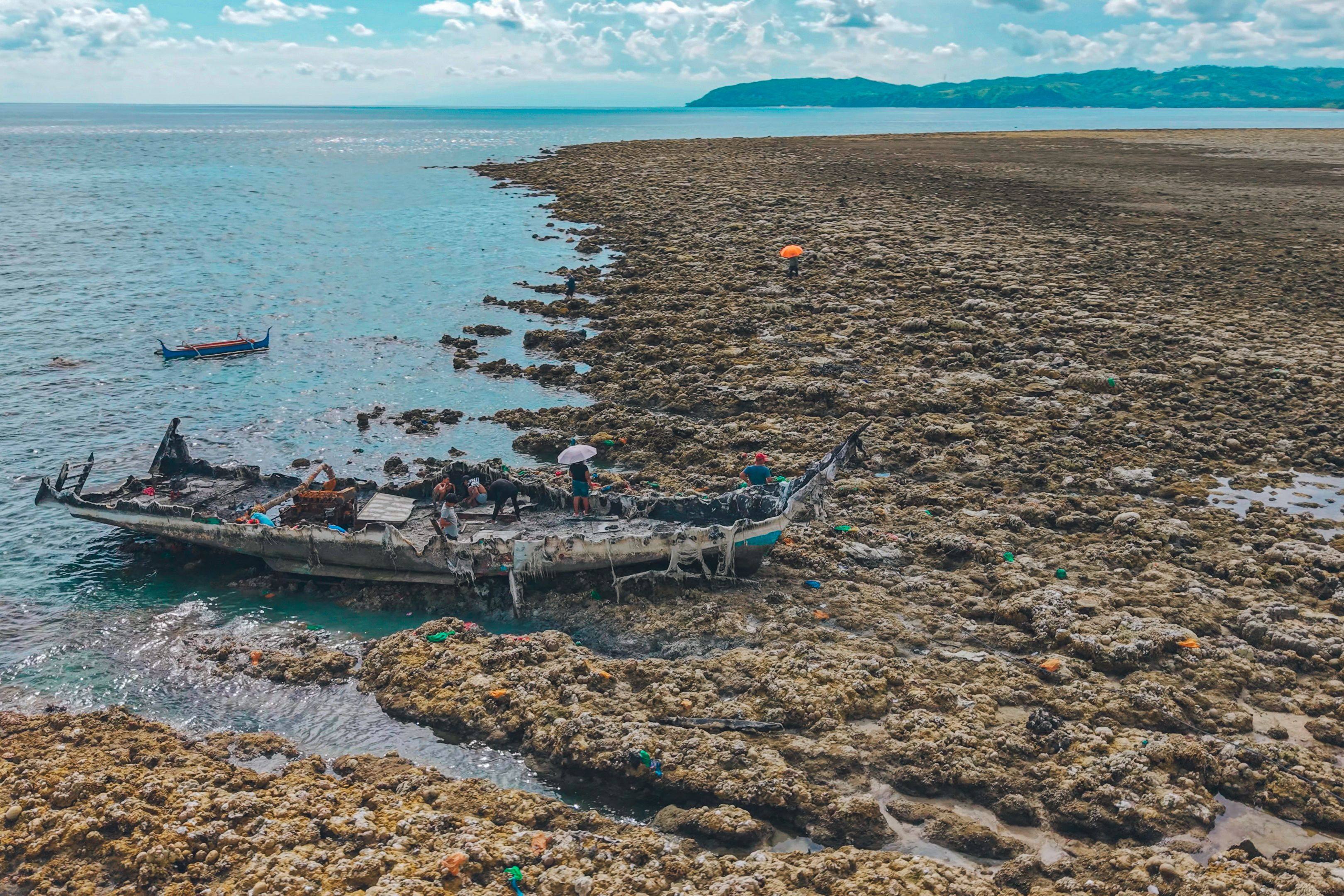 A fishing boat is stranded after the seabed is thrust upwards by the June 8 earthquake in the Philippines. Photo: AFP