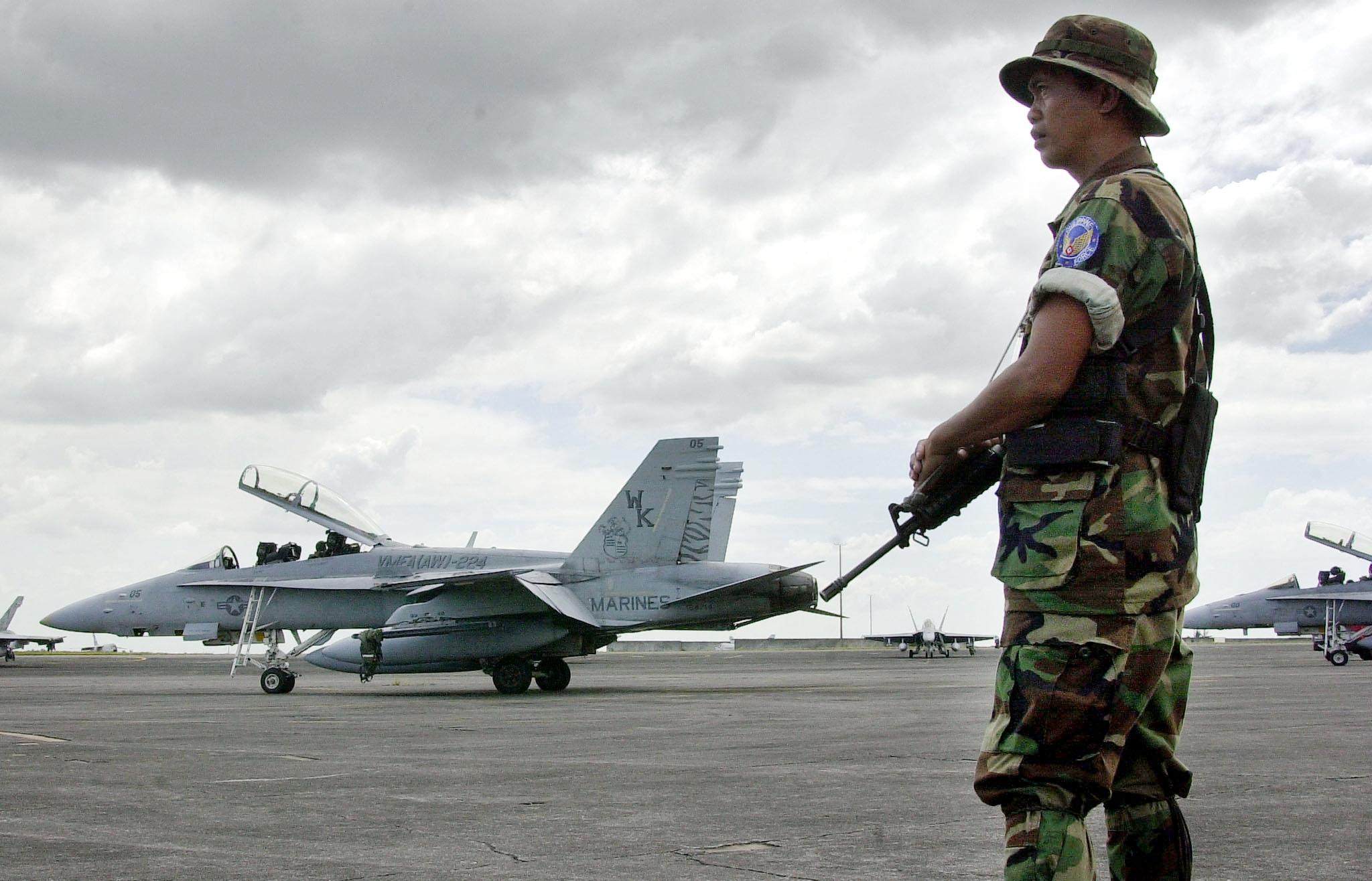 A Philippine soldier guards an American  F-18 fighter jets on a refuelling stop at Clark Airbase in 2001. Photo: AFP