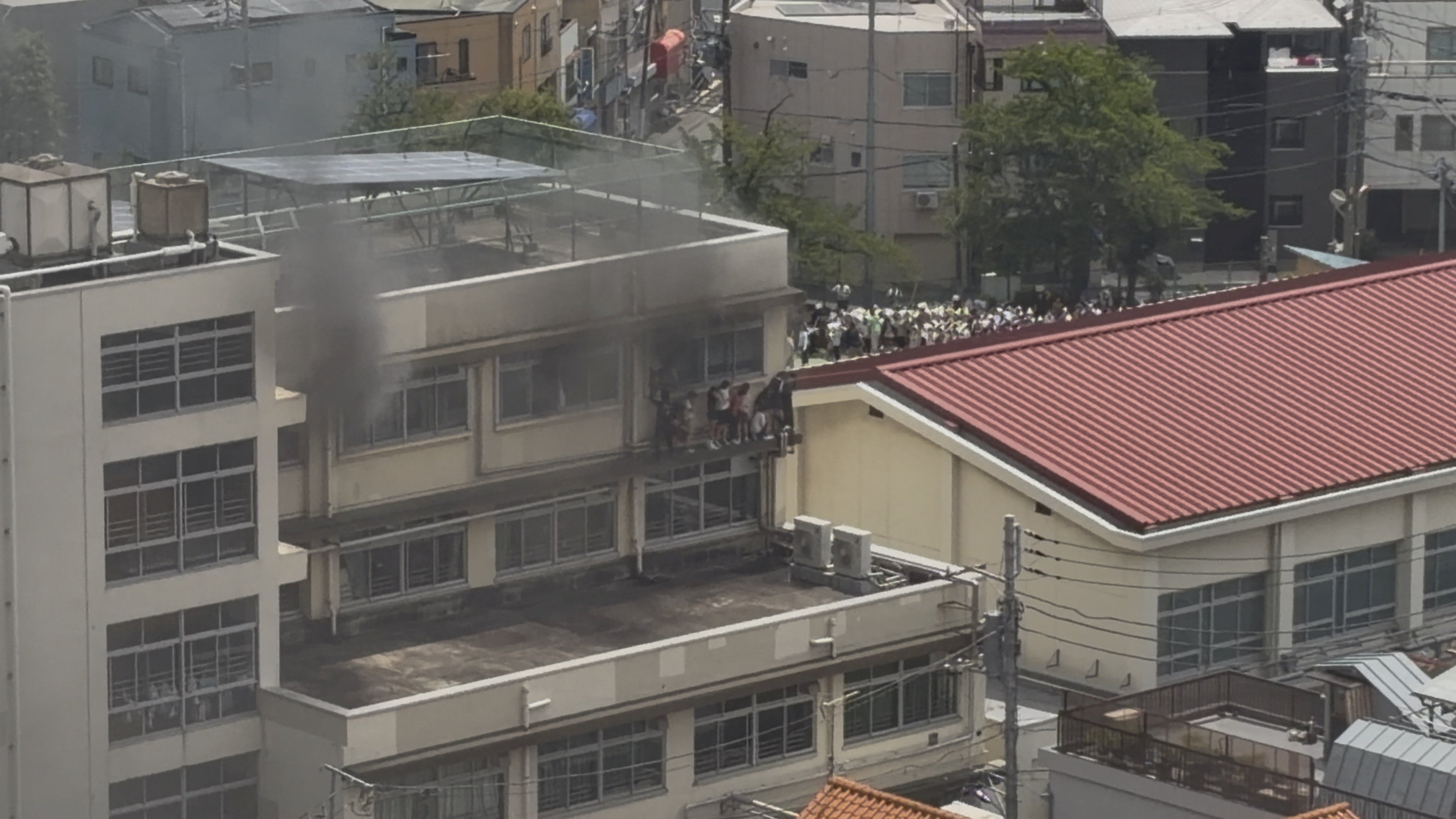 Smoke rises as students are evacuated from a primary school after a fire broke out in Kita city, Tokyo, on Friday. Photo: X/takanyo via Reuters