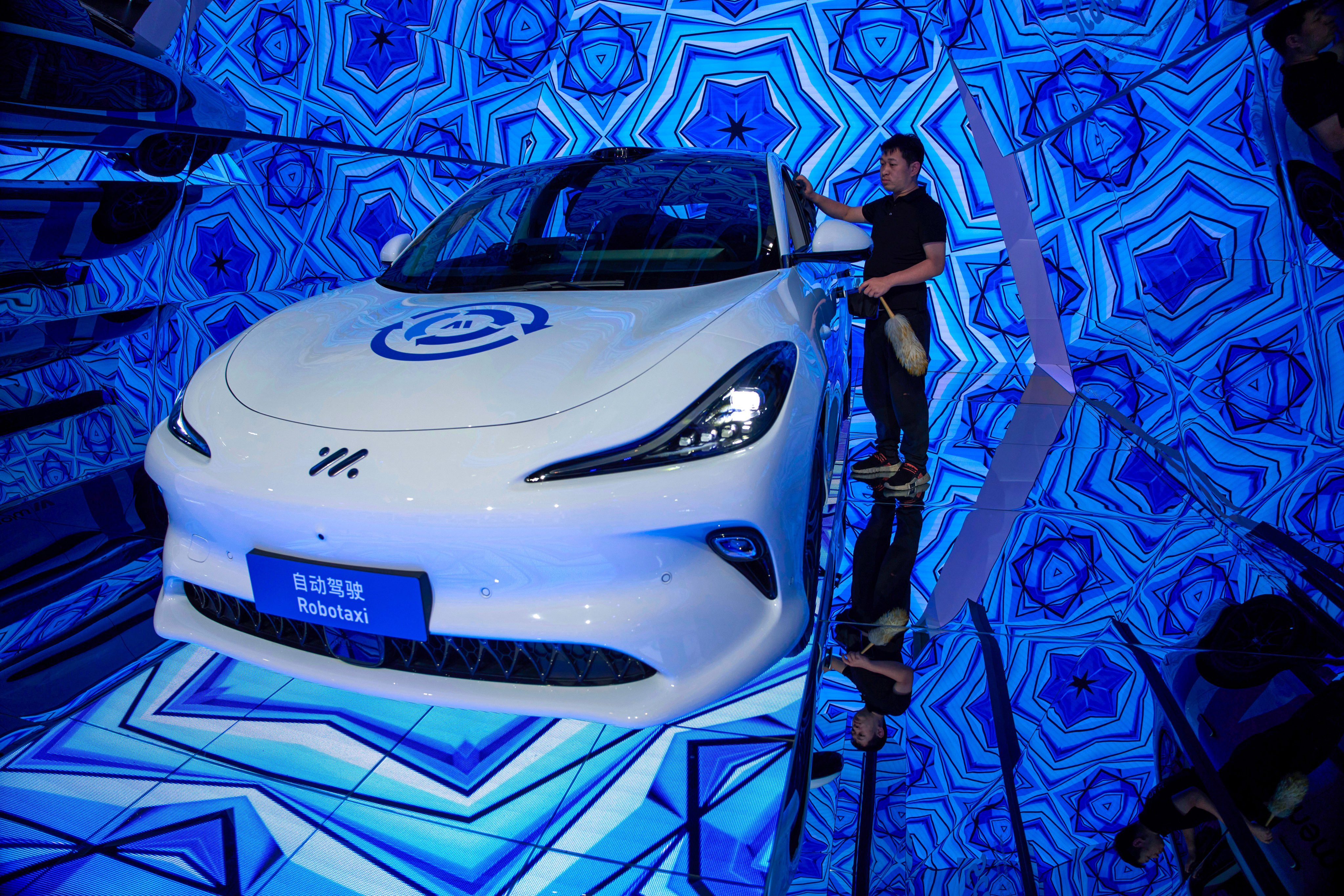 A worker cleans a Momenta robotaxi at last year’s Shanghai auto show. Photo: AP