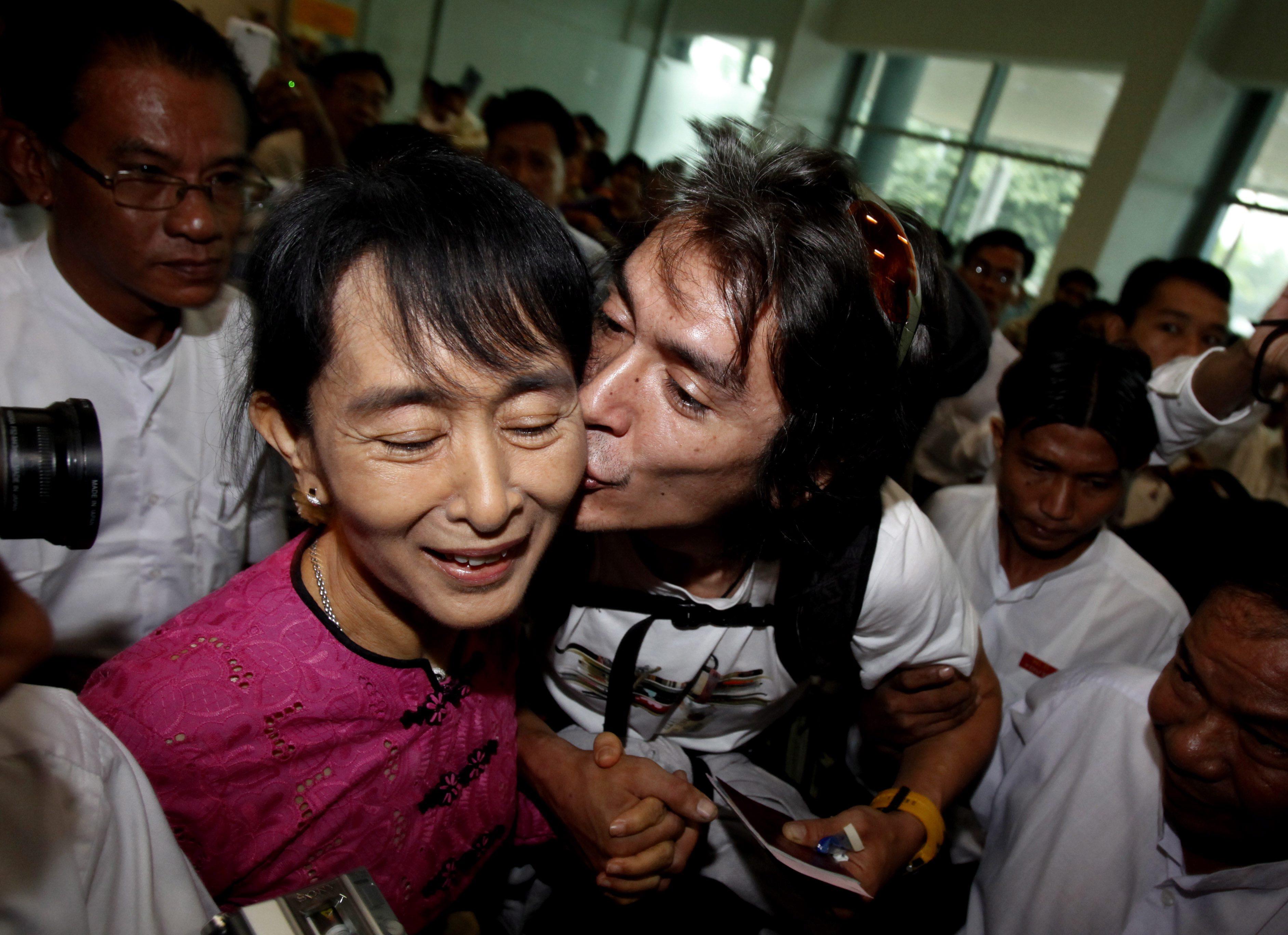 Aung San Suu Kyi receives a birthday kiss from her son Kim Aris upon his arrival at Yangon International Airport, Myanmar, on June 19, 2011. Photo: EPA