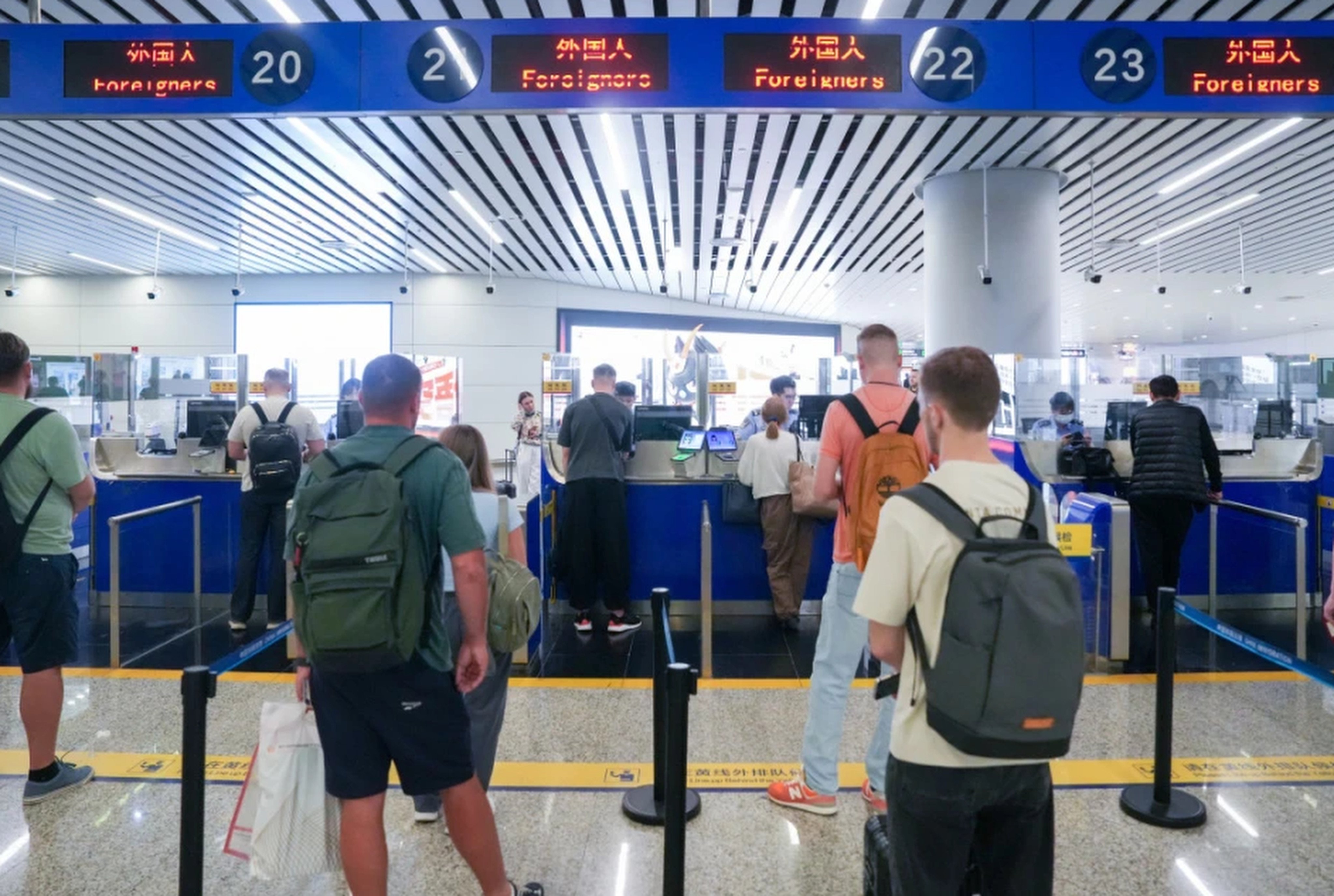 Russian nationals line up for immigration processing at the Baiyun Airport in Guangzhou. Photo: gzdaily