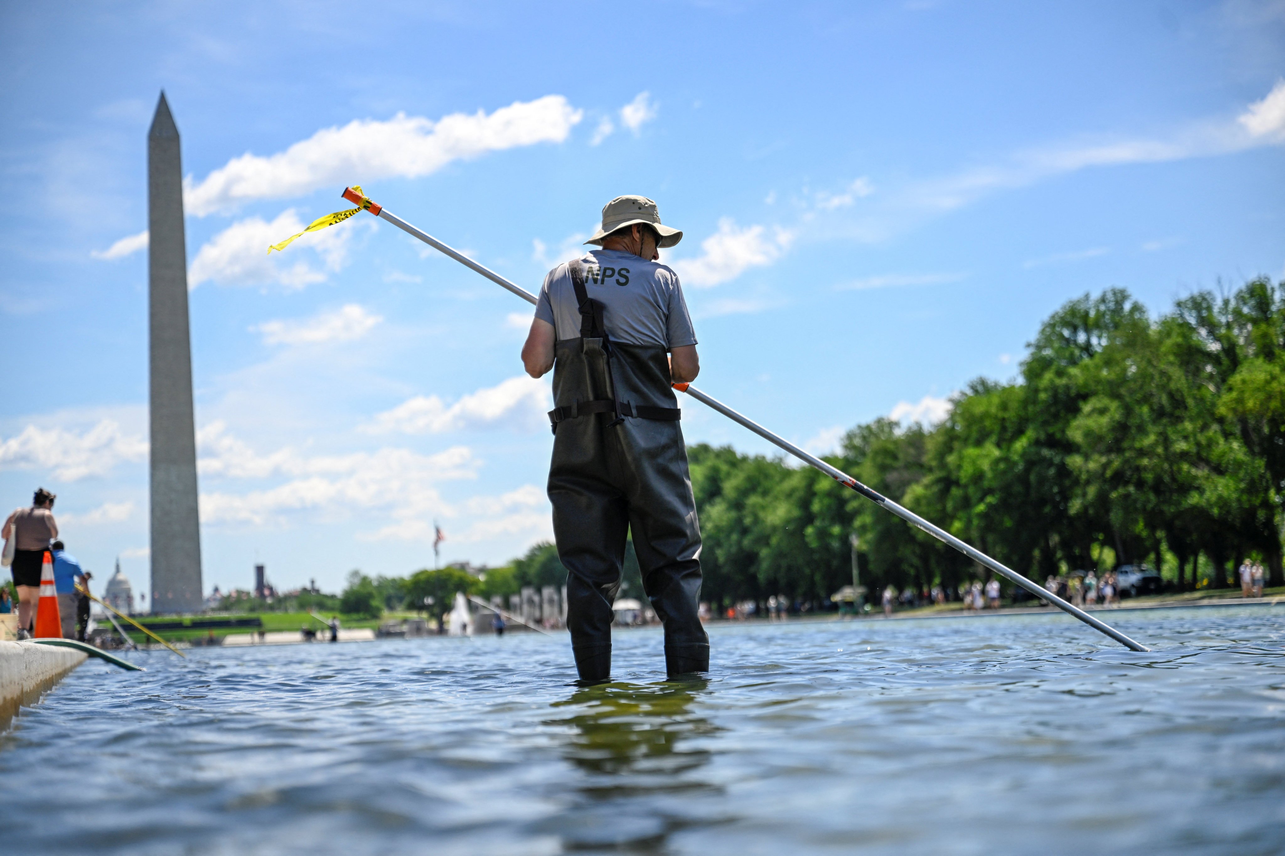 A US National Park Service employee works to remove algae in the Lincoln Memorial Reflecting Pool in Washington on Saturday. Photo: Reuters