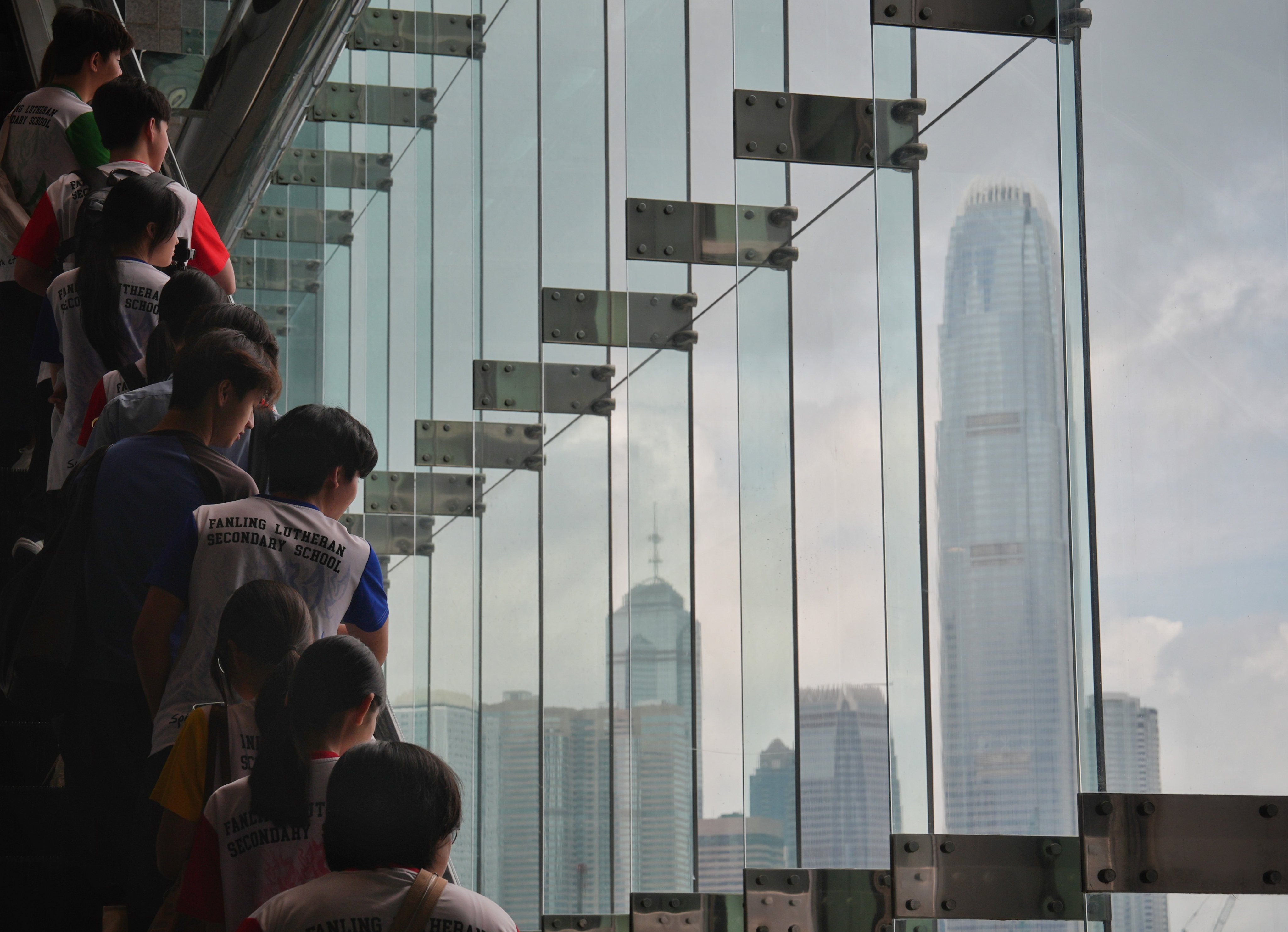 Students look out at the Hong Kong skyline while riding an escalator in Wan Chai. Photo: Elson Li