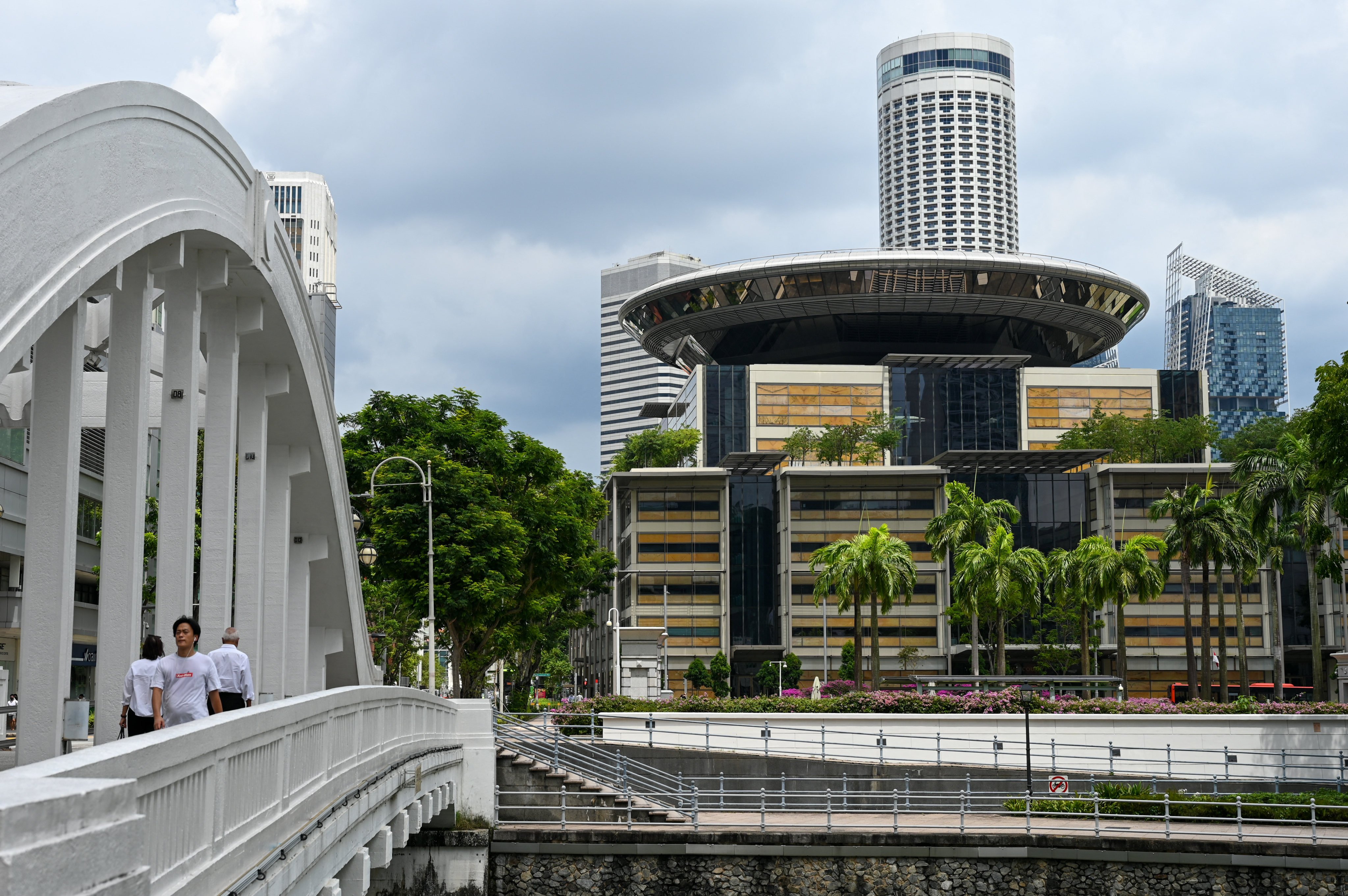 People walk across a bridge near the Supreme Court (right) in Singapore. Photo: AFP