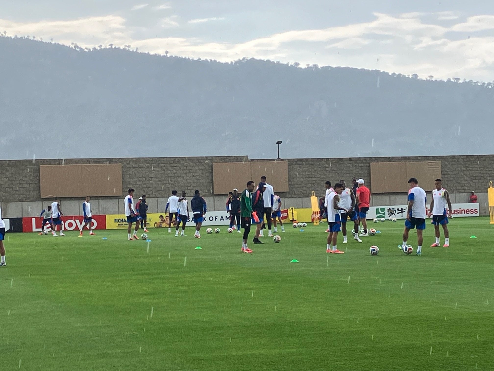 The Colombia players begin a training session as storm clouds gather over the Bosque de la Primavera forest and mountain range in the distance. Photo: Paul McNamara