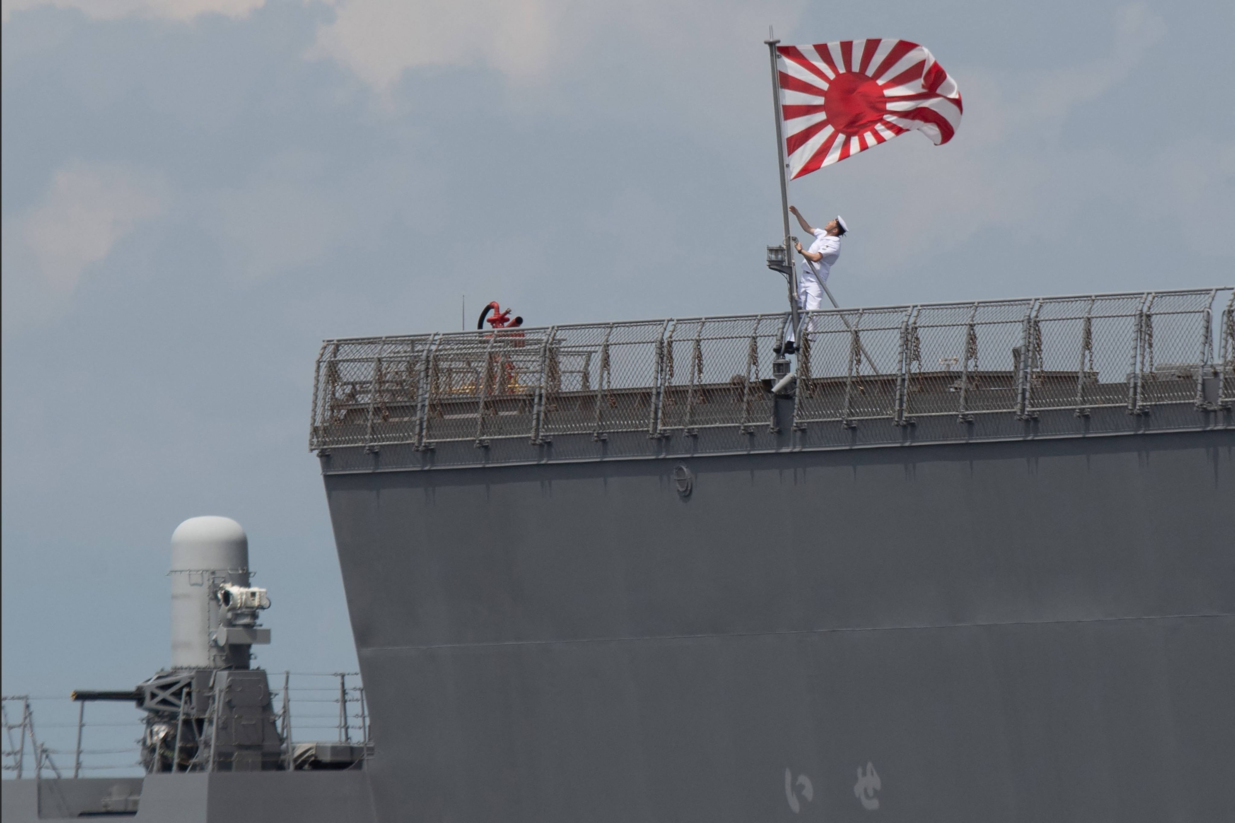 A sailor raises the Japan Maritime Self-Defence Force ensign on board the JS Ise, a helicopter destroyer, as it docks at the international port in Manila in June last year. Photo: AFP