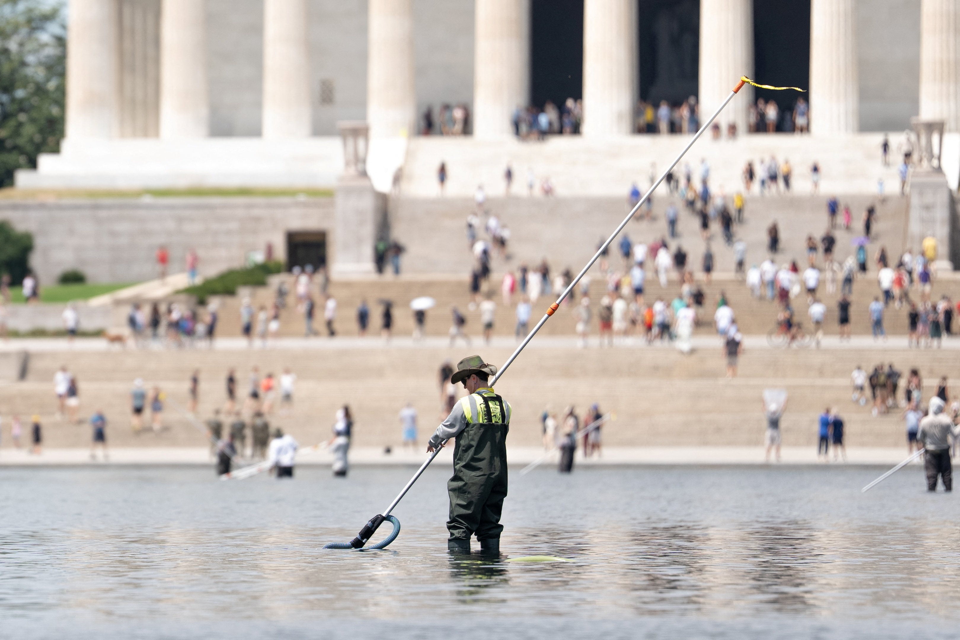 A worker vacuums algae from the pool. Photo: Reuters
