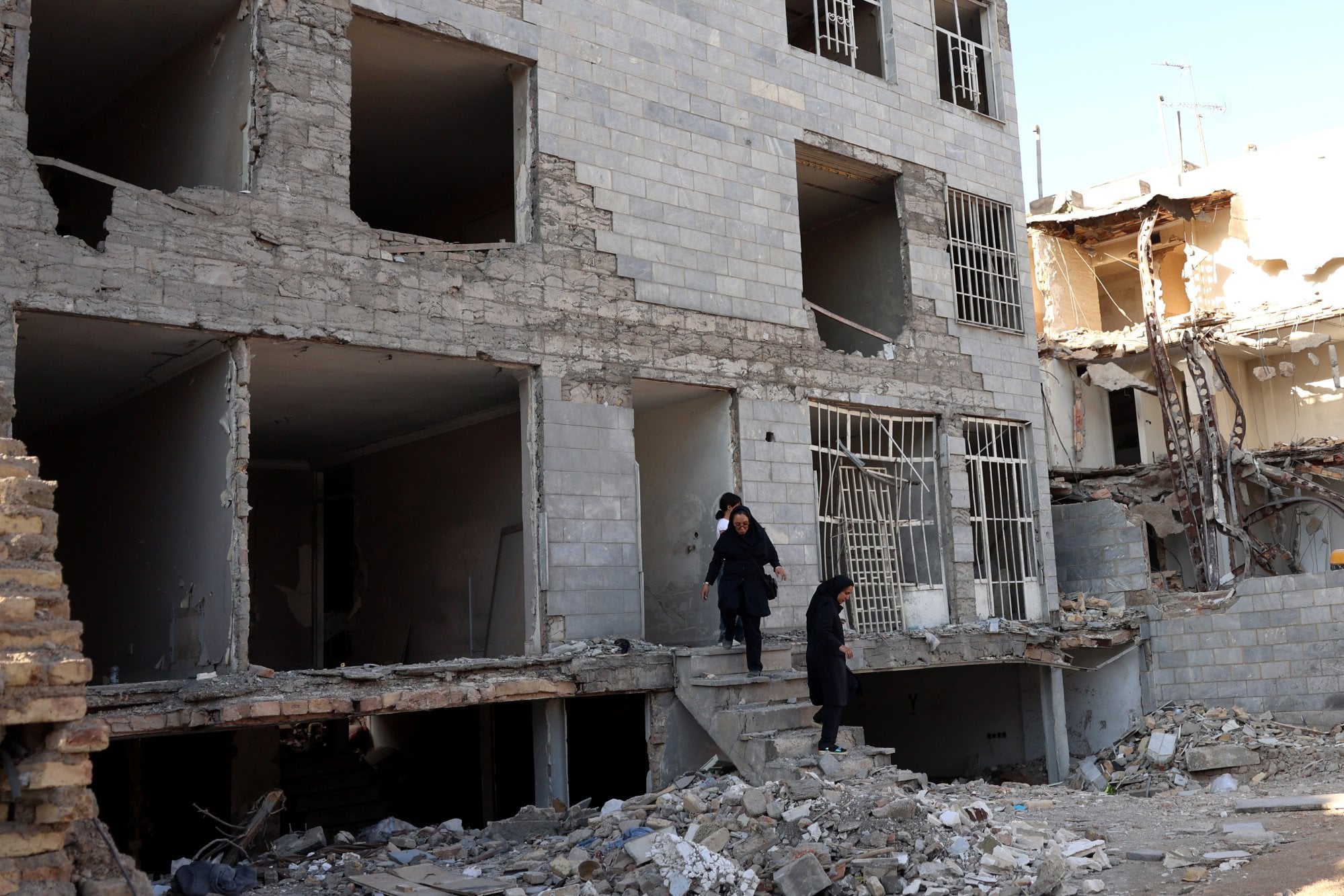 Iranian women inspect a residential building in Tehran destroyed by previous US-Israeli strikes. Photo: EPA