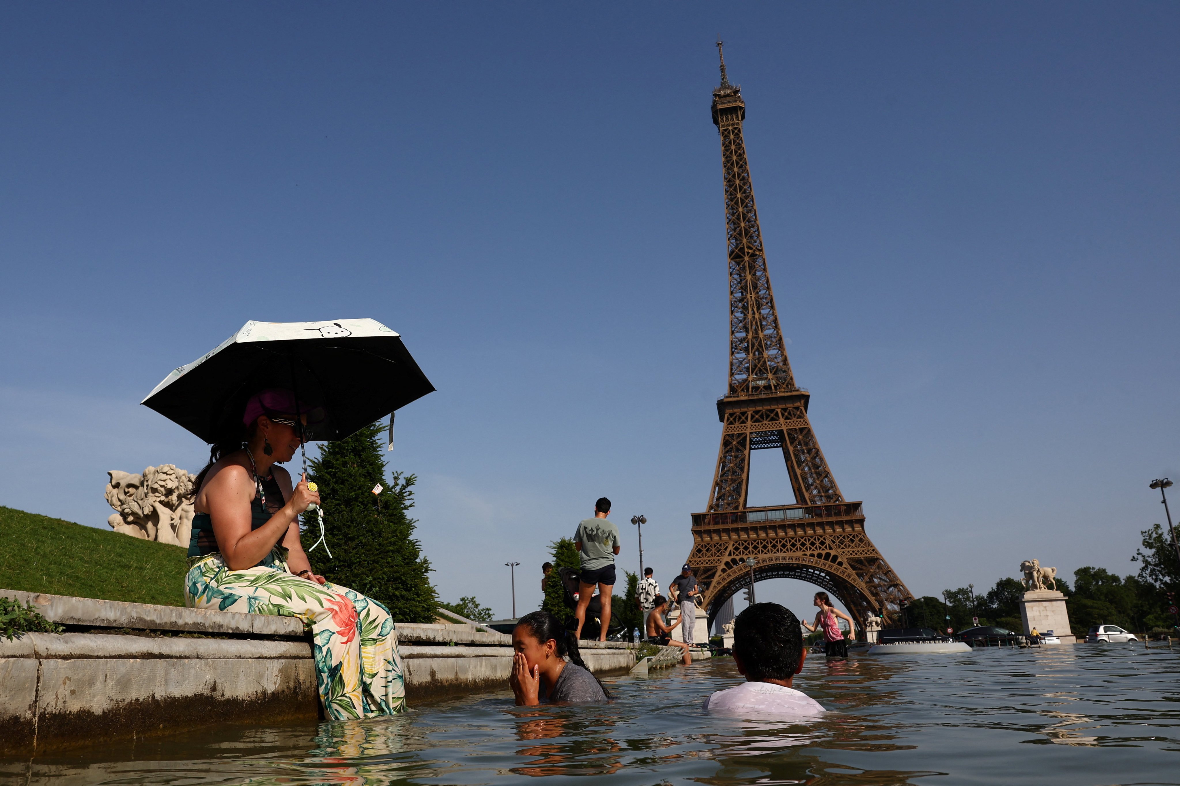 People cool off in the Trocadero fountain in front of the Eiffel Tower on Tuesday as a punishing early-summer heatwave sends temperatures soaring across France. Photo: Reuters