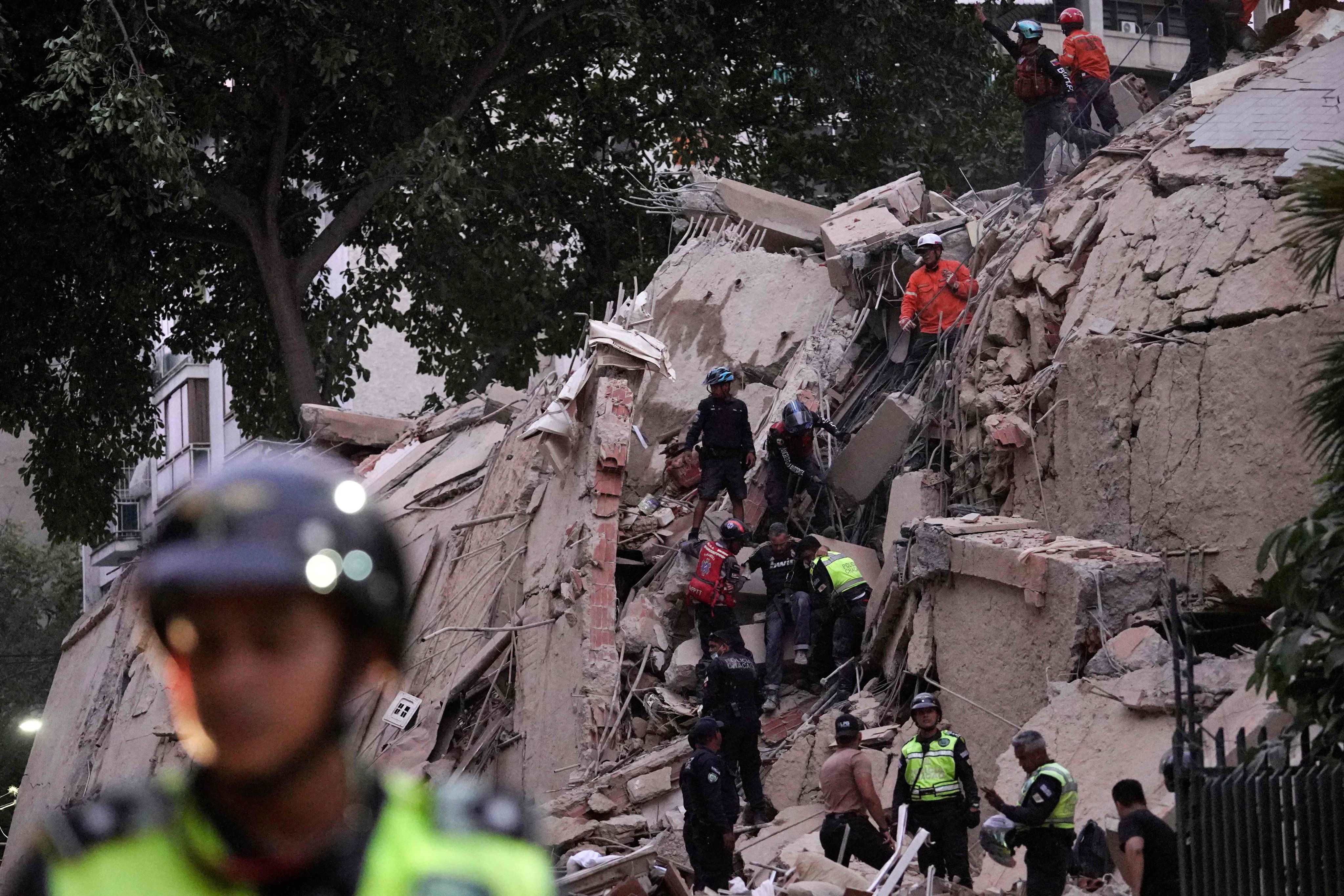 Rescuers help an injured person from a collapsed building in Caracas. Photo: AFP