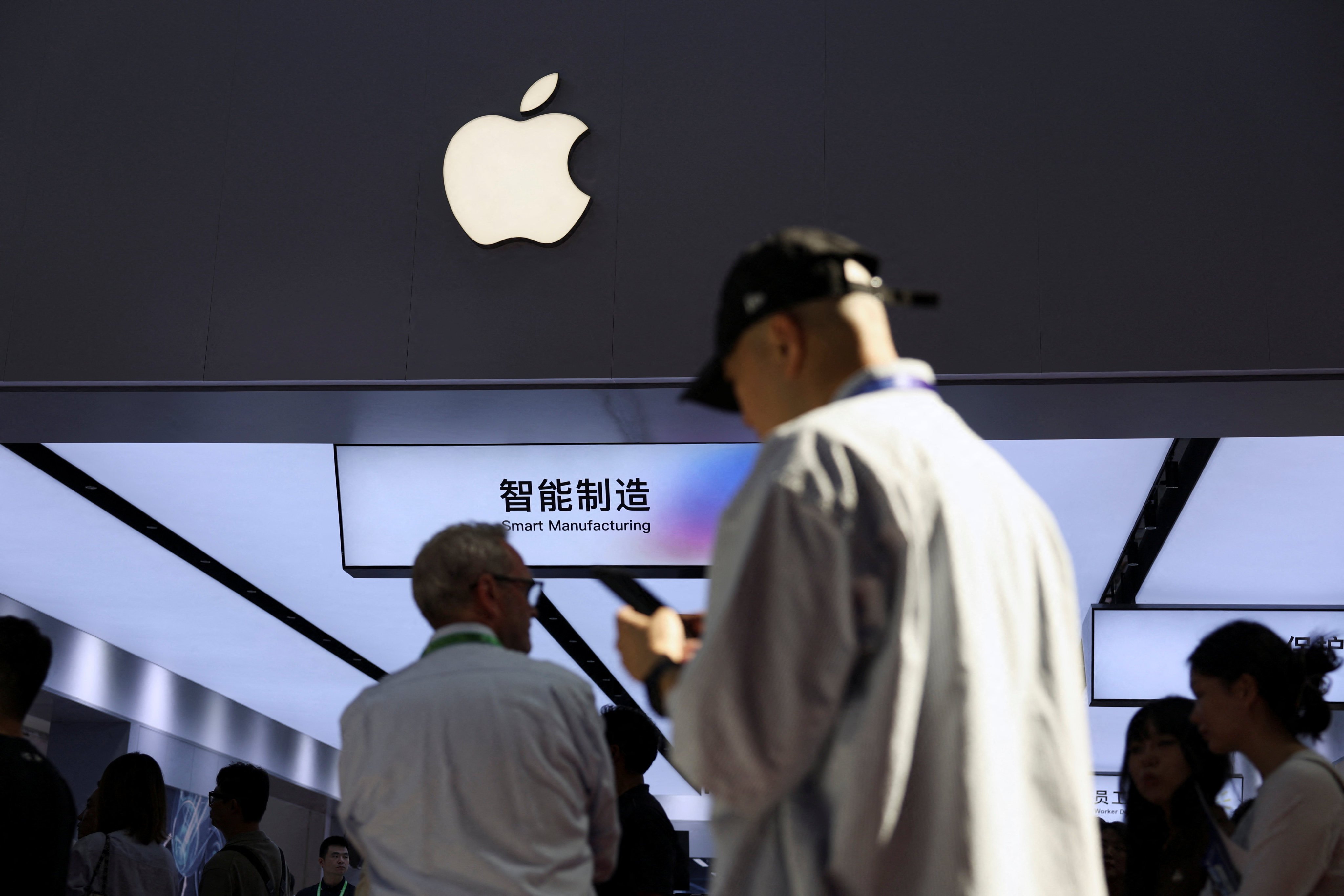 People walk past a booth showcasing Apple’s suppliers during the China International Supply Chain Expo in Beijing on June 22. Photo: Reuters