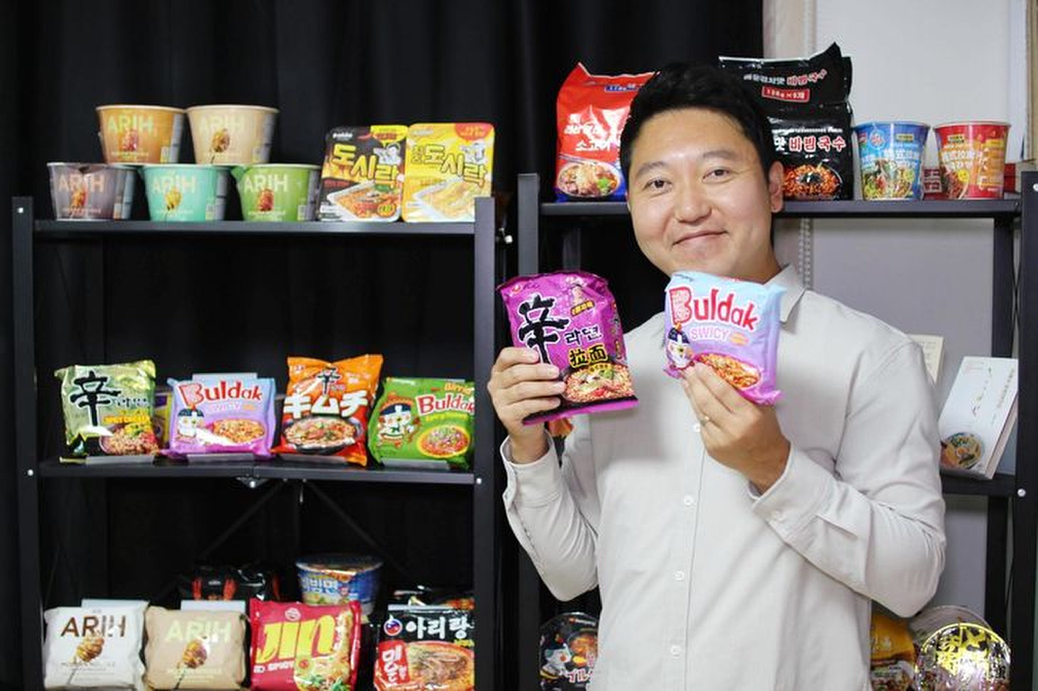 Instant noodle critic and expert Ji Young-jun holds packets of Shin Ramyun and Buldak Swicy Spicy Ramen, two of the most-loved Korean instant noodles. Photo: courtesy of Ji Young-jun