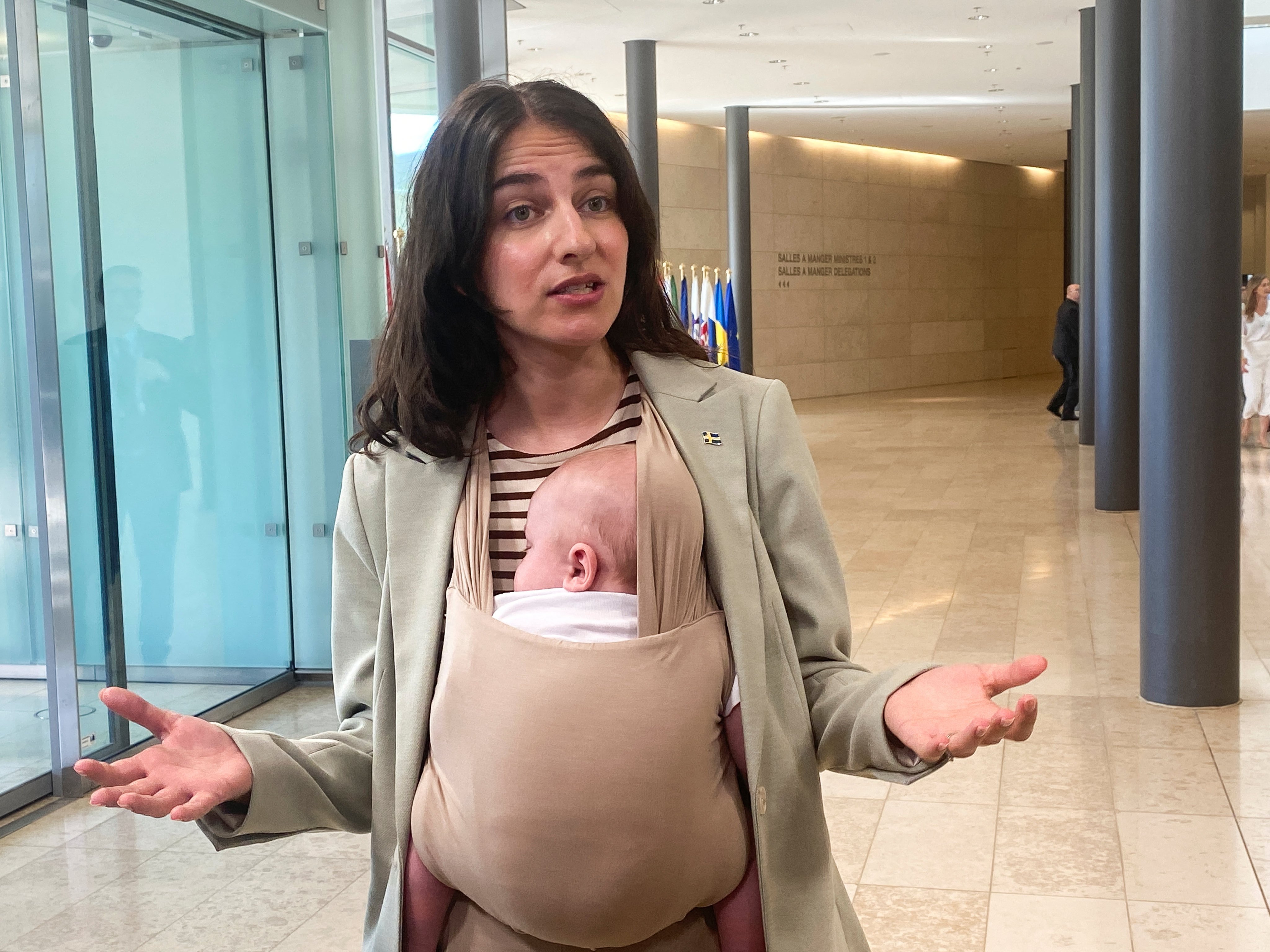 Swedish Environment Minister Romina Pourmokhtari, carrying her baby Adam, speaks to journalists before a meeting of EU environment and climate ministers, in Luxembourg on Thursday. Photo: Reuters