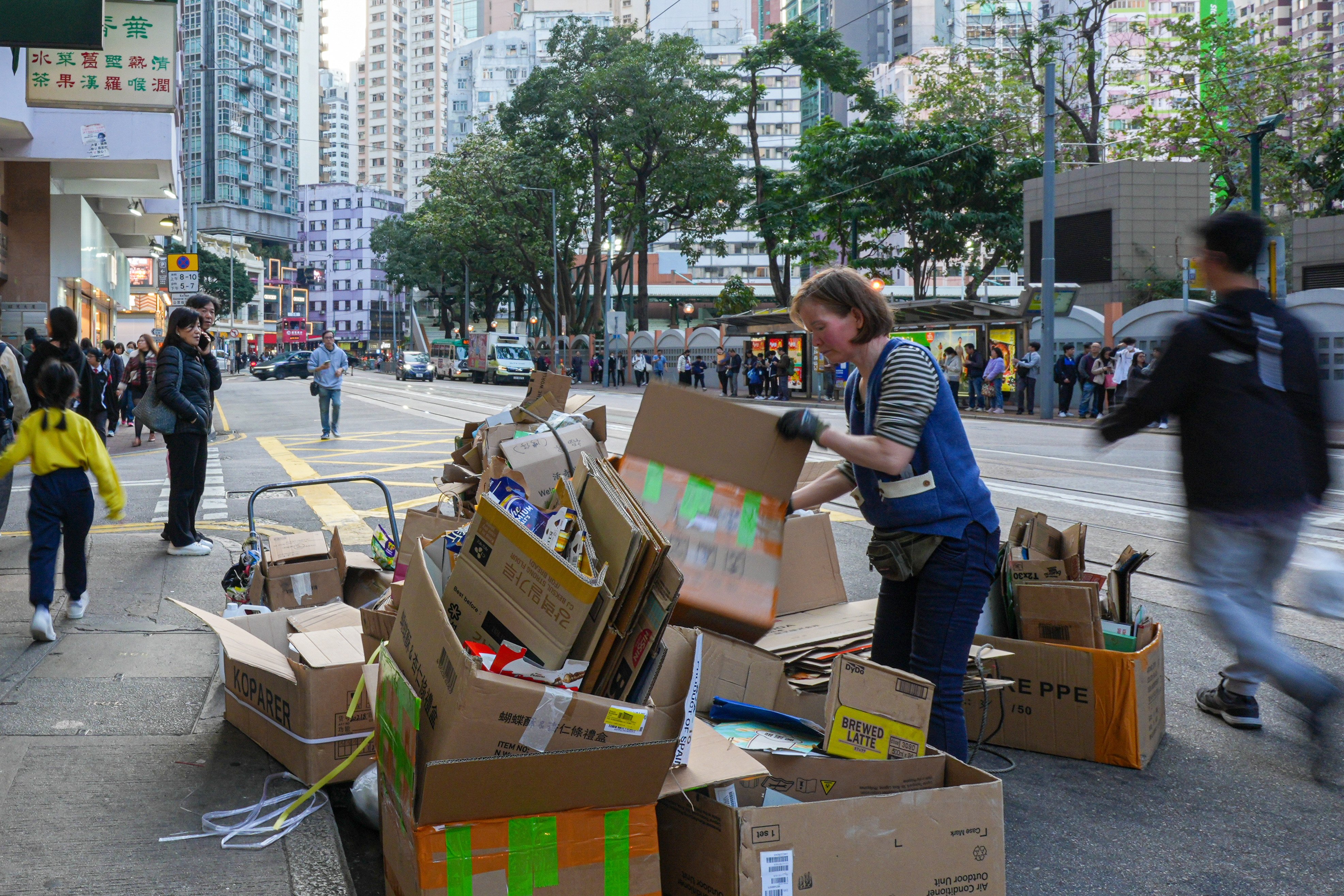 A woman collects cardboard in Wan Chai to sell to recyclers. Photo: Eugene Lee