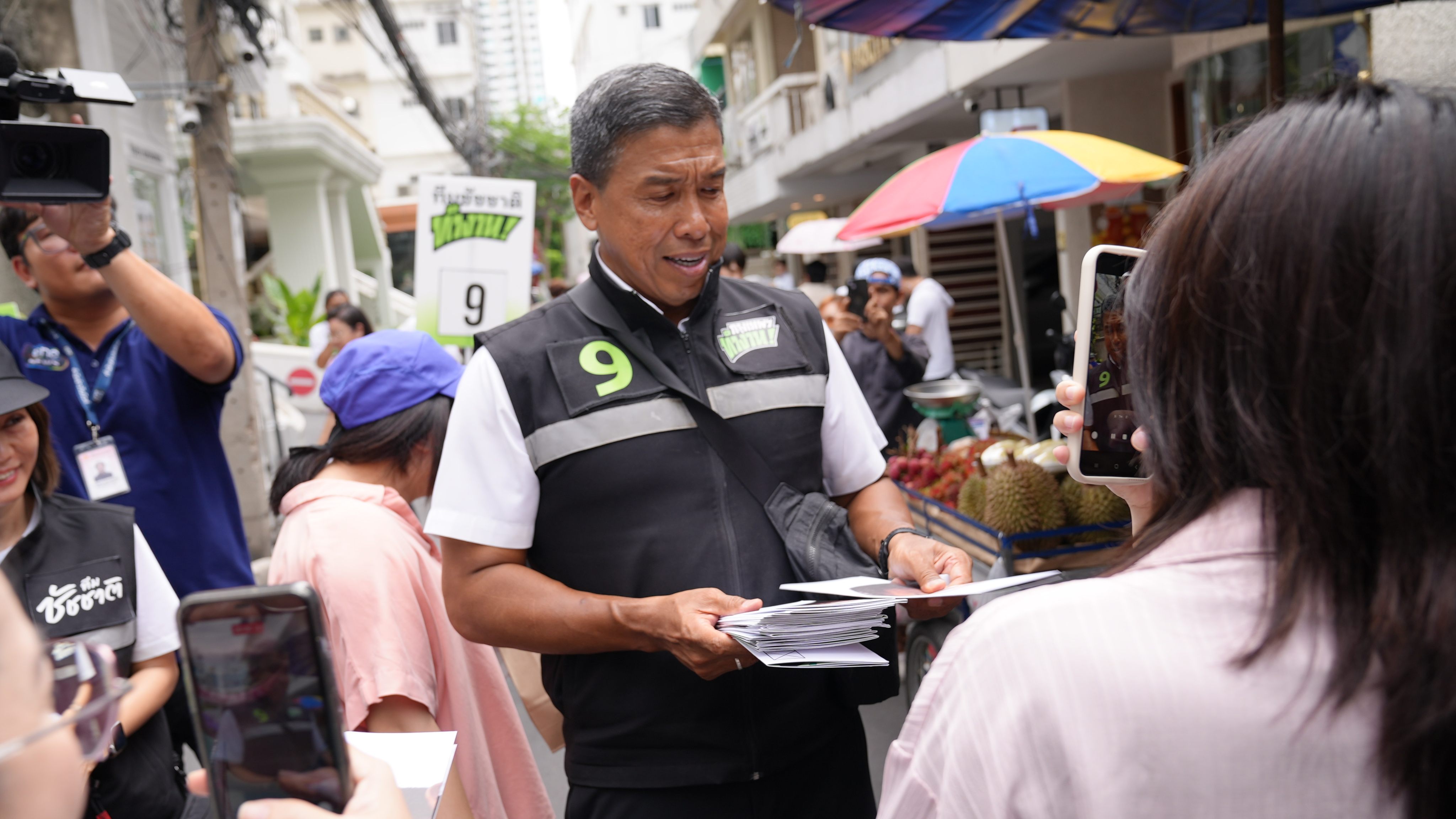 Bangkok governor Chadchart Sittipunt hands out leaflets while campaigning trail in the Thai capital. Photo: Aidan Jones