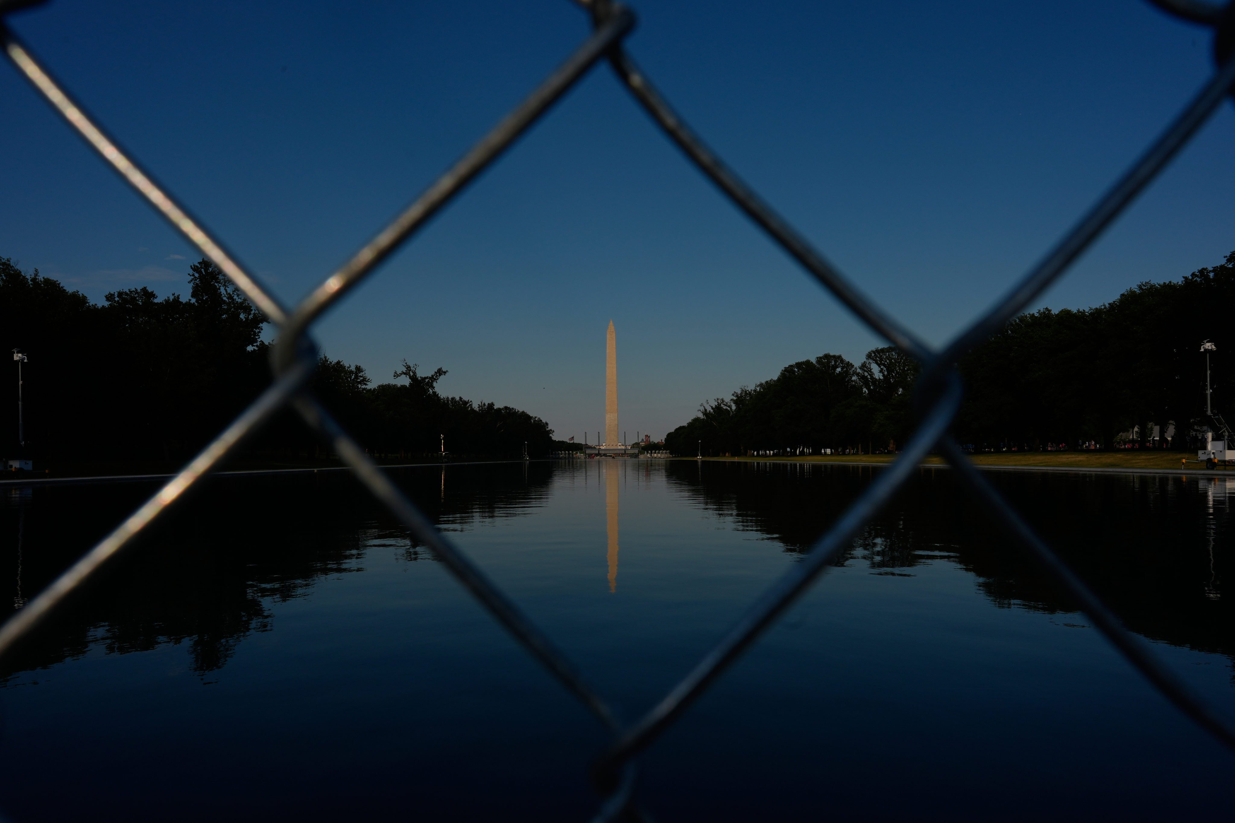 The Washington Monument, reflected in the Lincoln Memorial Reflecting Pool, as seen behind a chain link fence on Thursday Photo: AP