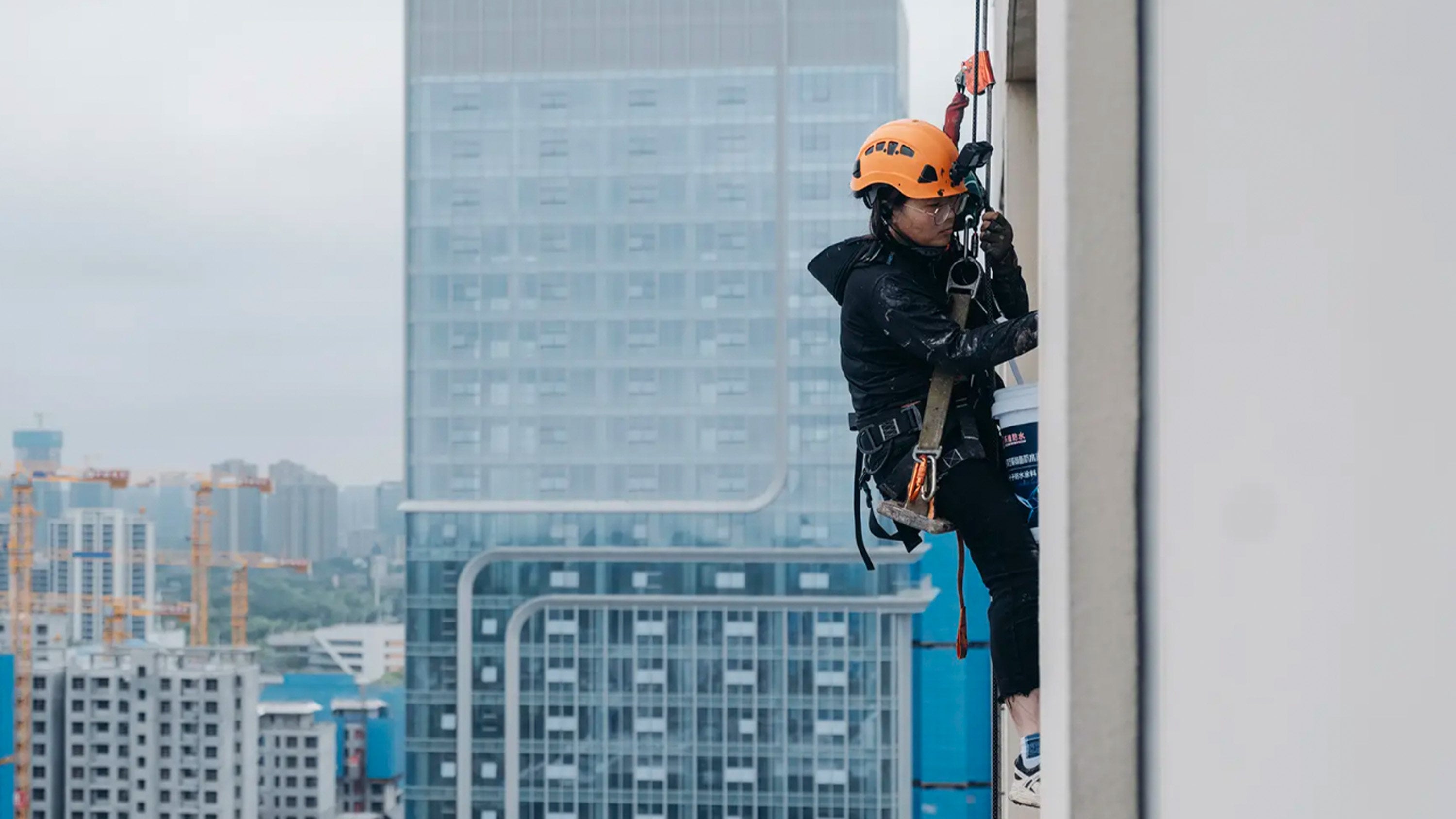 A 36-year-old single mother in China, dubbed “Spider-Woman,” cleans and repairs high-rise buildings to support her family. Photo: Sohu