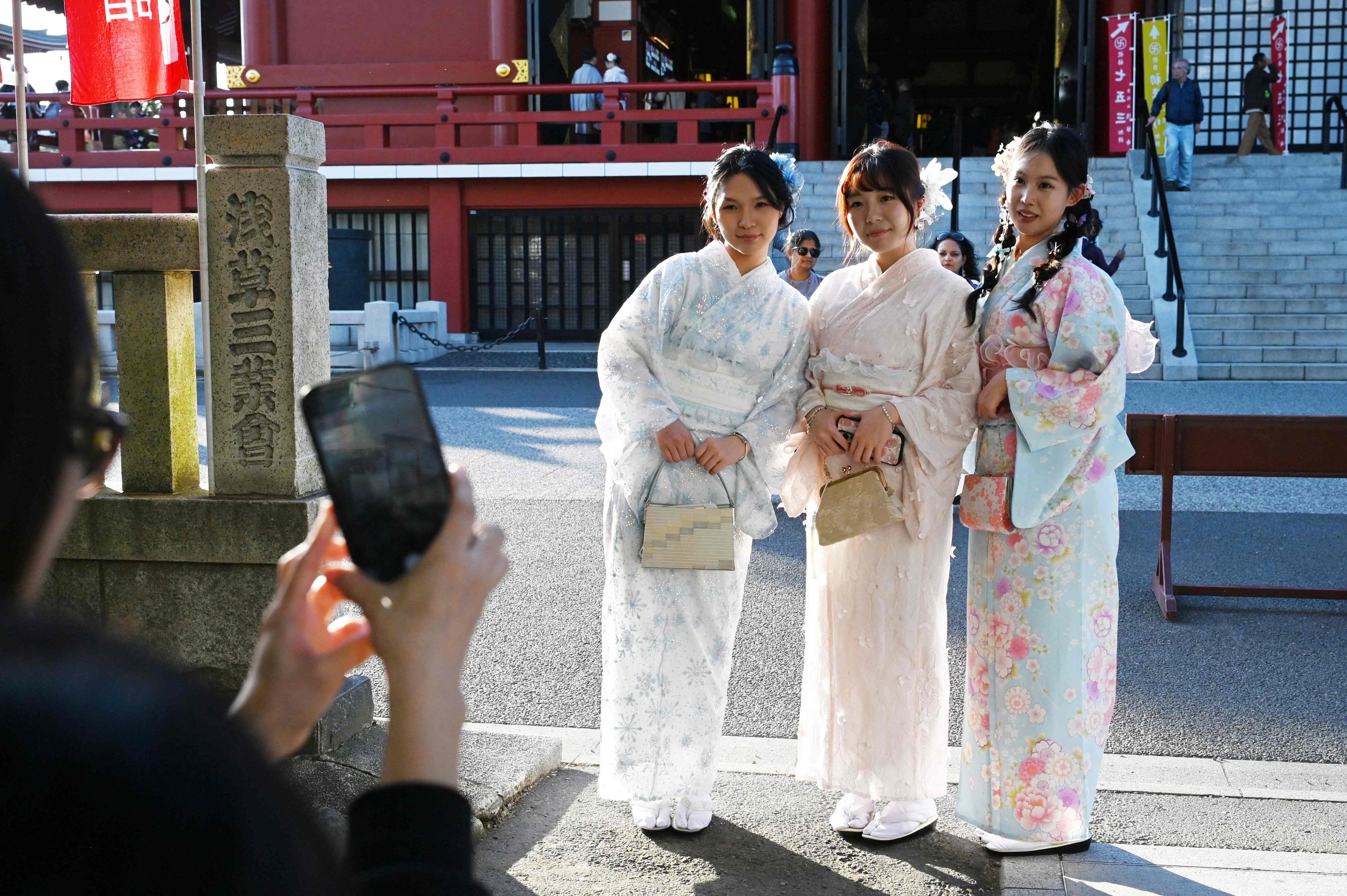 Chinese tourists pose for photographs while dressed in kimonos at the Sensoji Temple in the Asakusa district of Tokyo. Photo: AFP