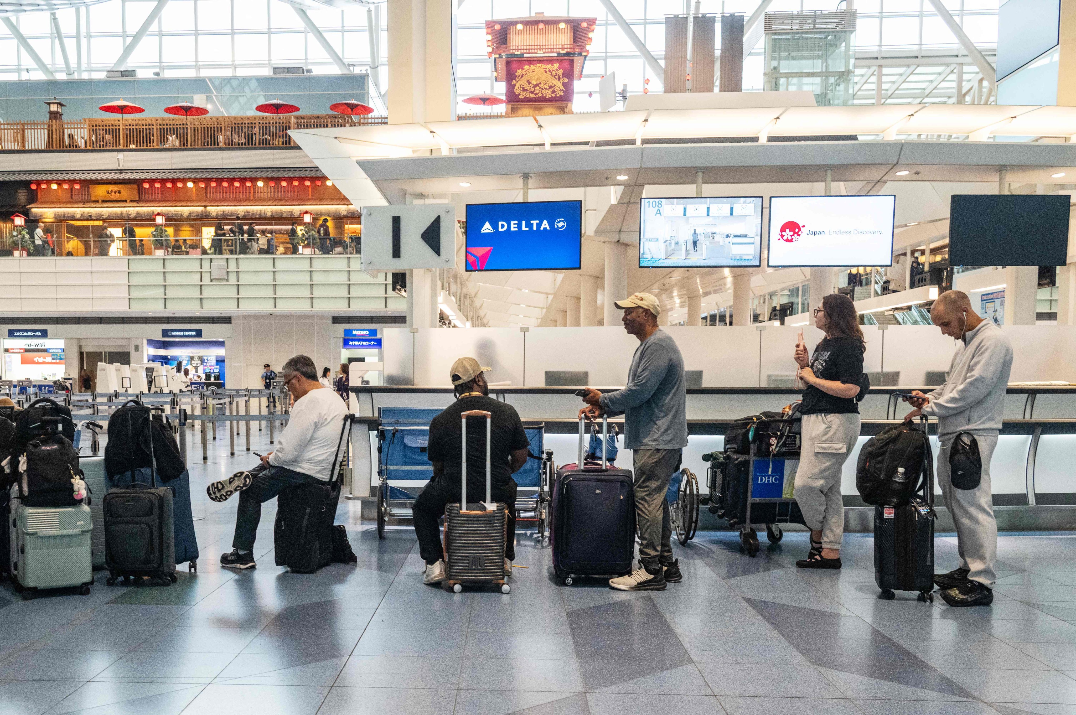 Passengers wait at Haneda airport in Tokyo on June 3. Photo: AFP
