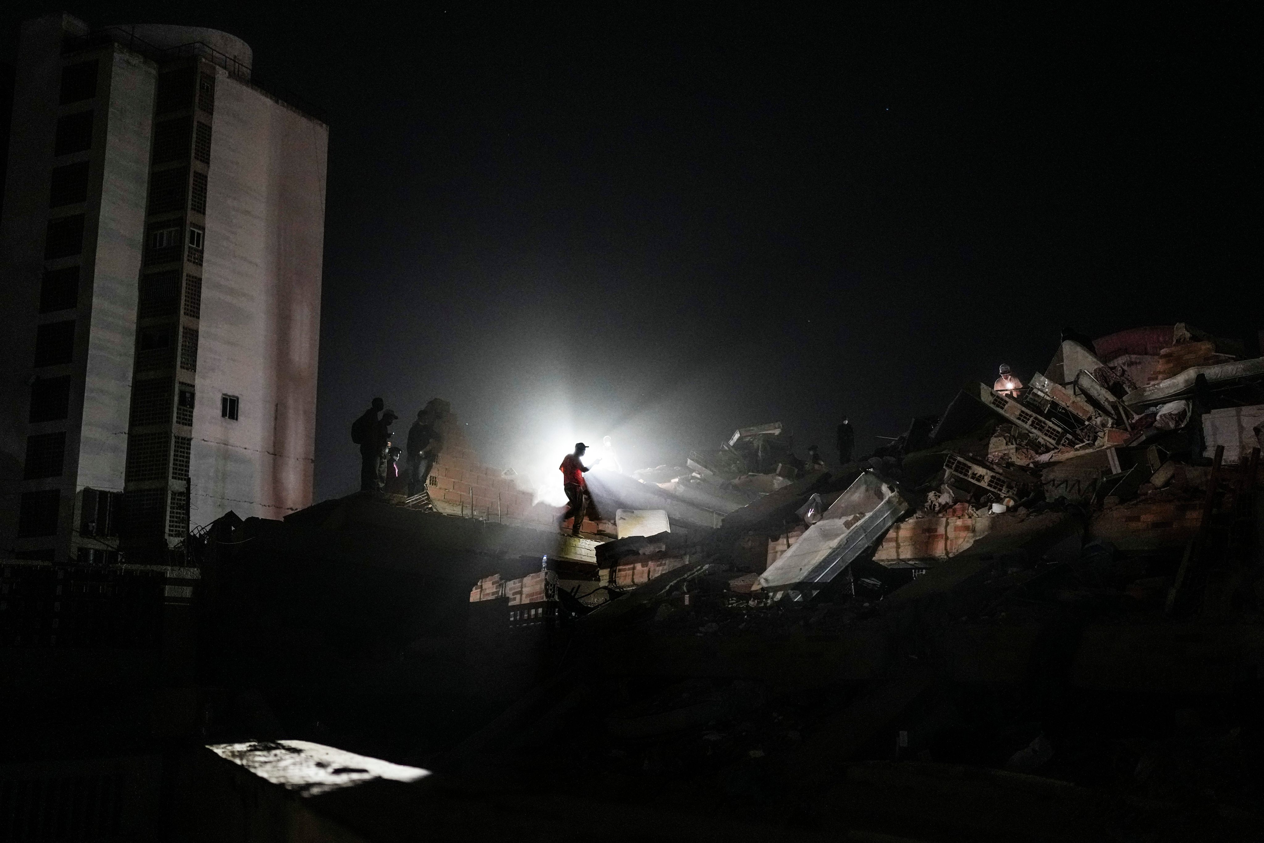 Residents and rescue workers search through the rubble two days after an earthquake struck in La Guaira, Venezuela, on Friday. Photo: AP
