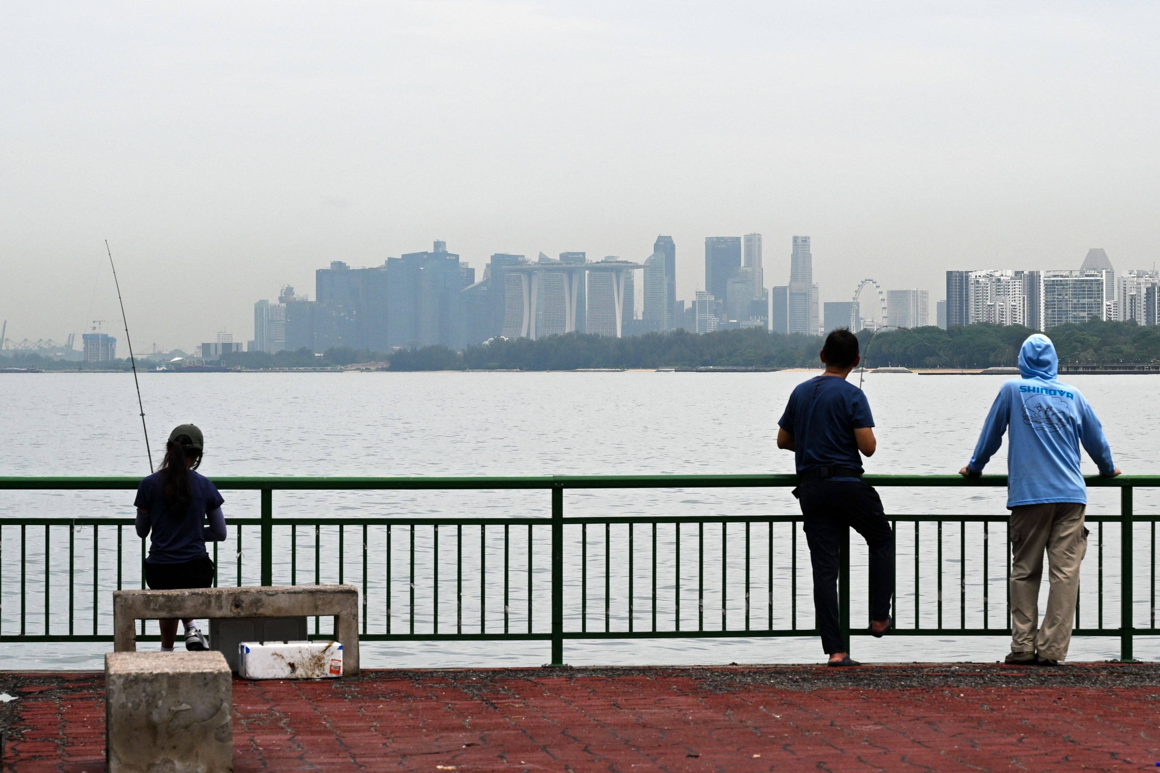 People look out from a jetty overlooking the city skyline in Singapore. Photo: AFP