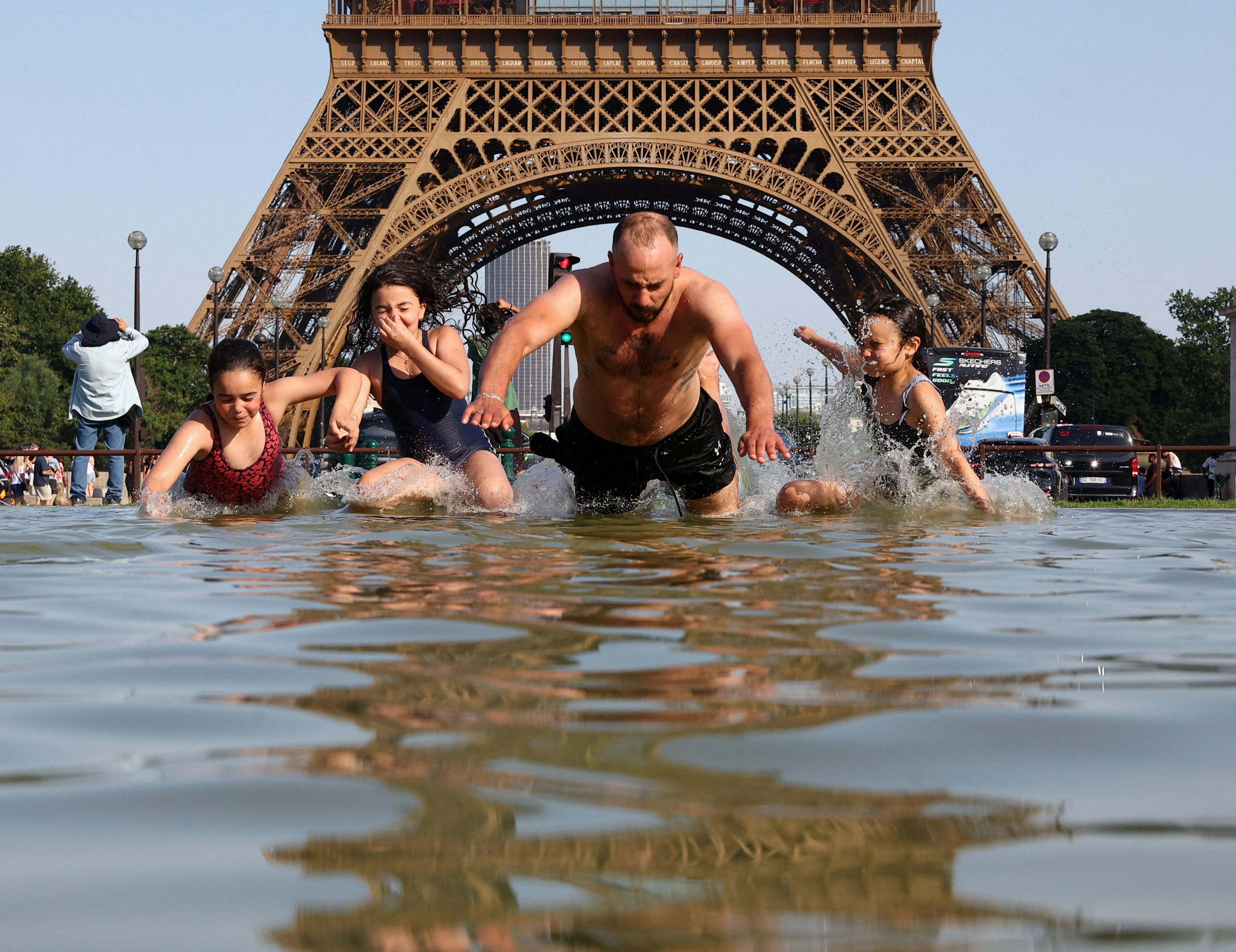 People cool off in the Trocadero Fountain next to the Eiffel Tower as temperatures rise during a heatwave affecting a large part of the country, in Paris, France, on Monday. Photo: Reuters