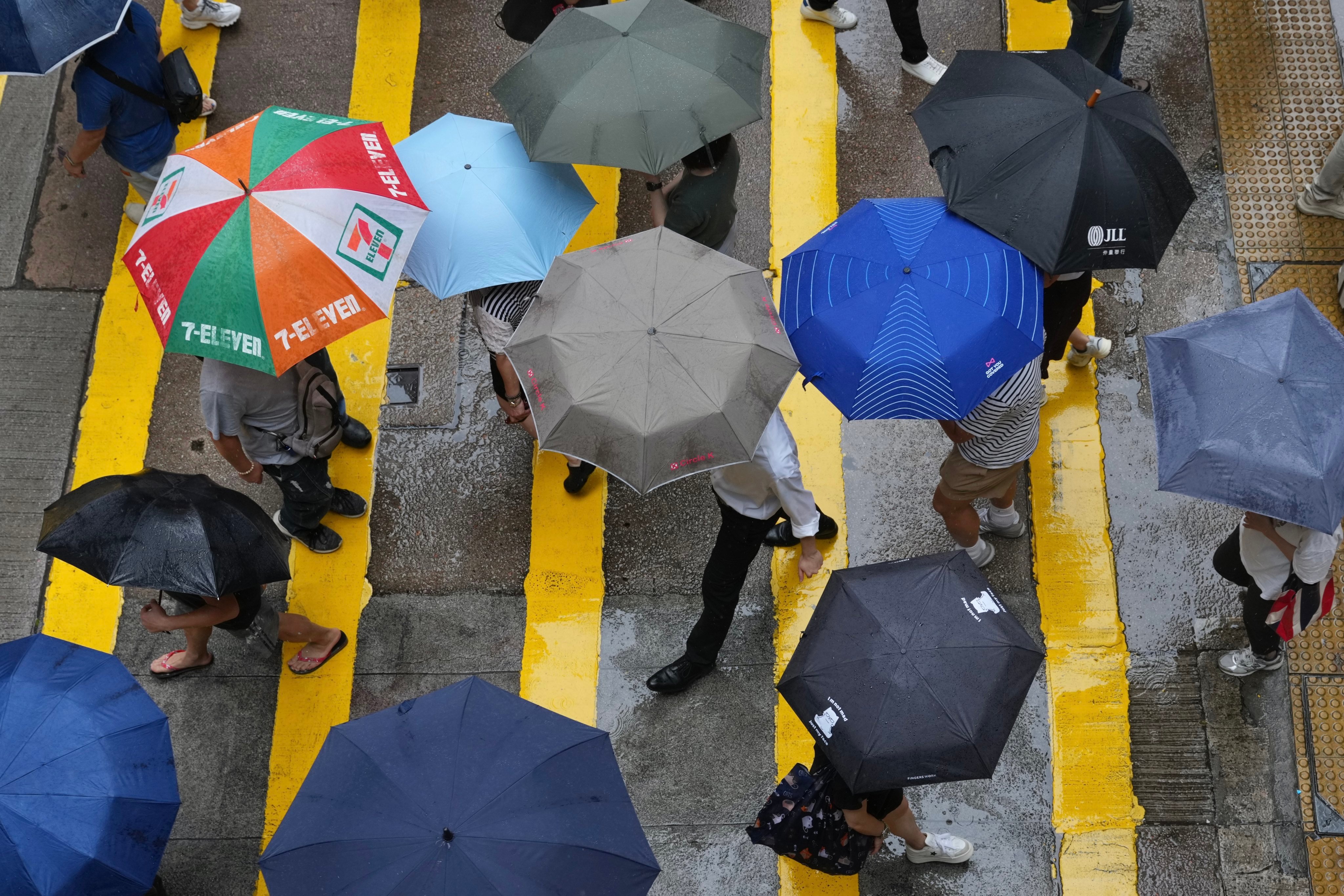 Pedestrians shelter under umbrellas in Wan Chai. Photo: Karma Lo