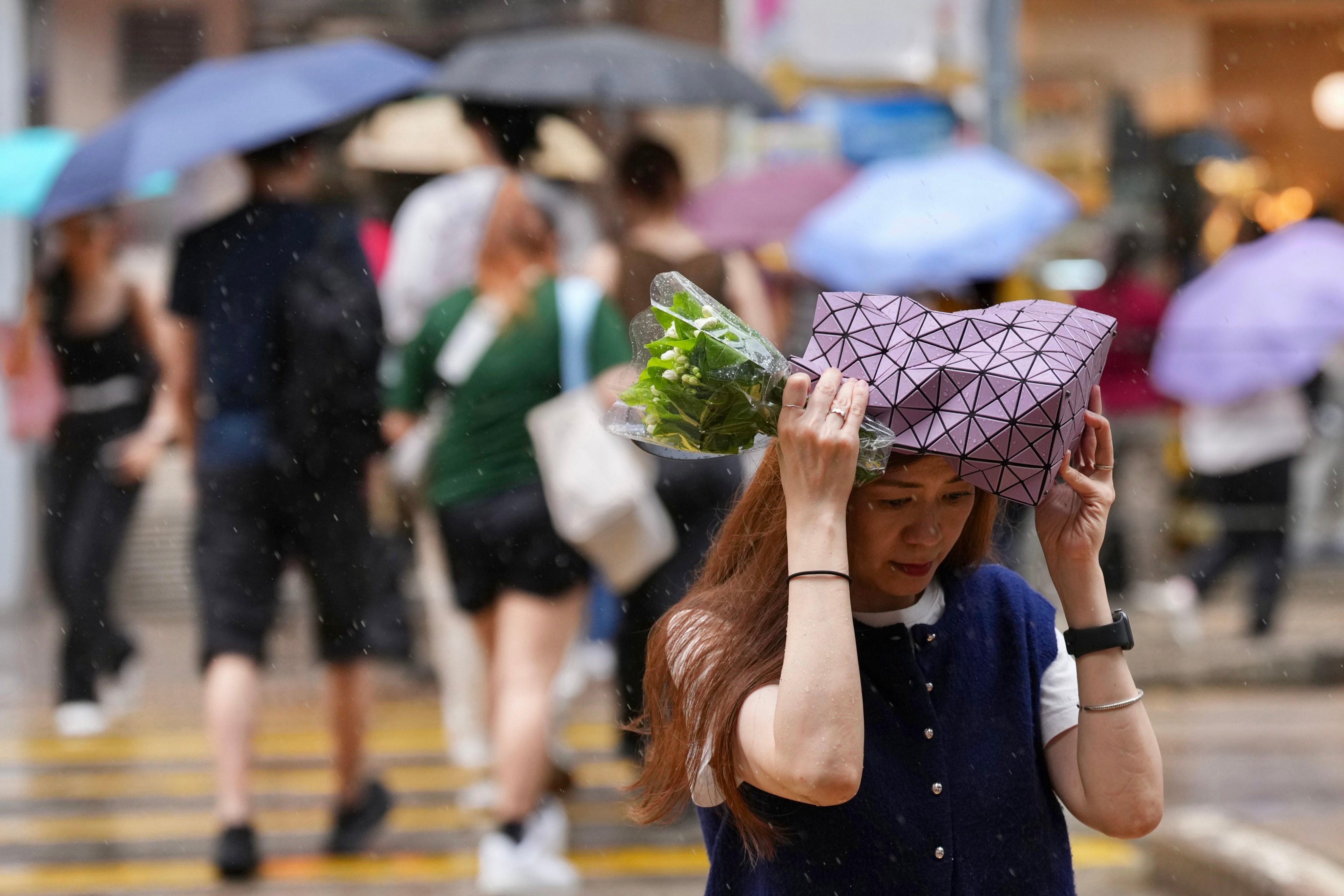 A pedestrian shields herself from rain in Wan Chai. Photo: Karma Lo
