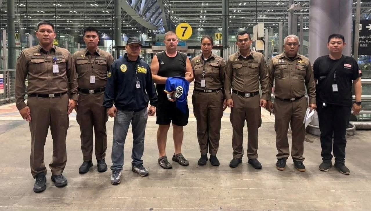 Police officers pose with Carman Simon Peter, an Australian man arrested in the suspected murder of a 17-year-old Thai girl in Pattaya, at Suvarnabhumi International Airport, Thailand on Saturday.   Pattaya Provincial Photo: Police via Reuters