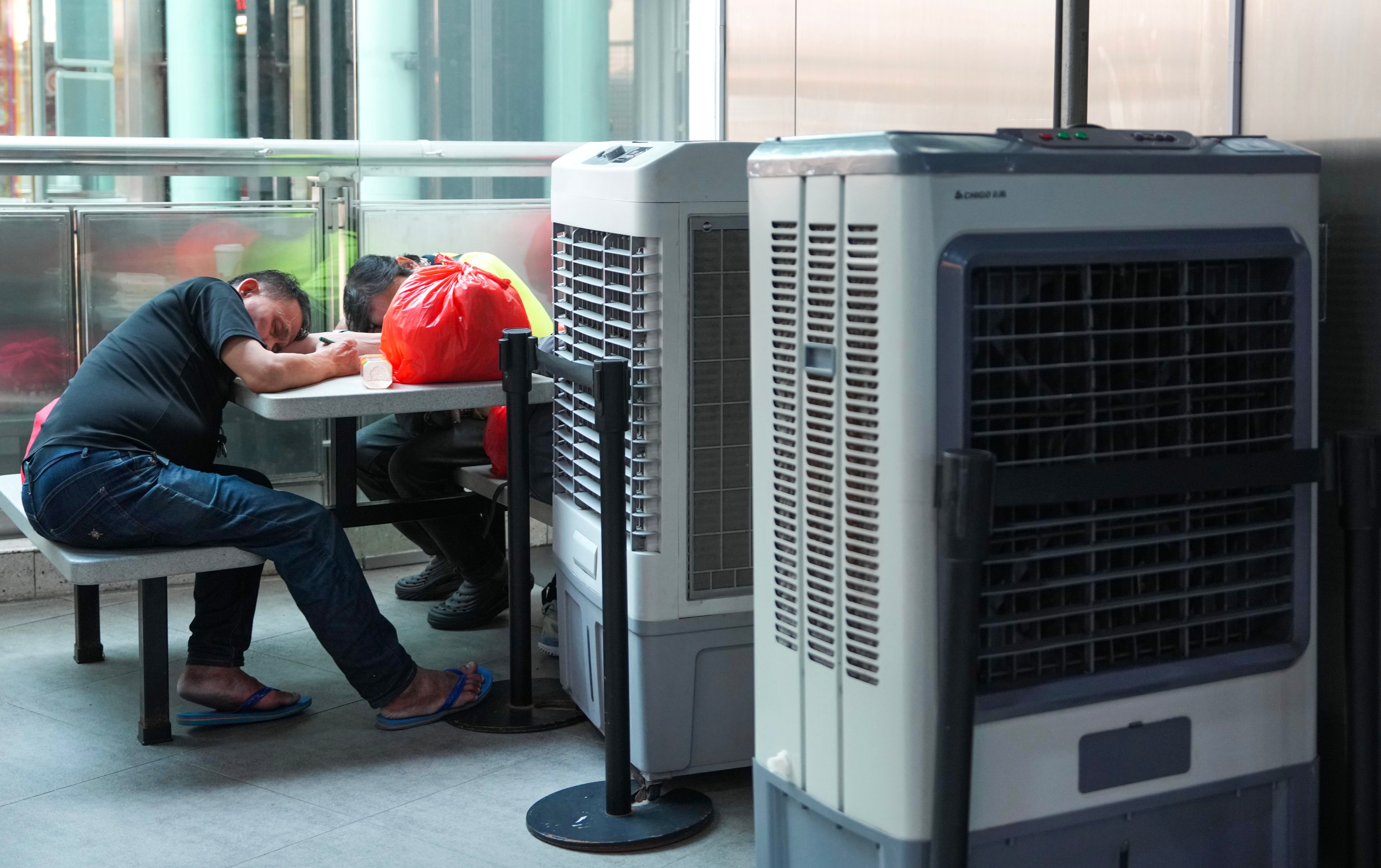 People sleep next to air-conditioning units in a shopping mall in Sham Shui Po, Hong Kong, on June 3. Photo: Sam Tsang