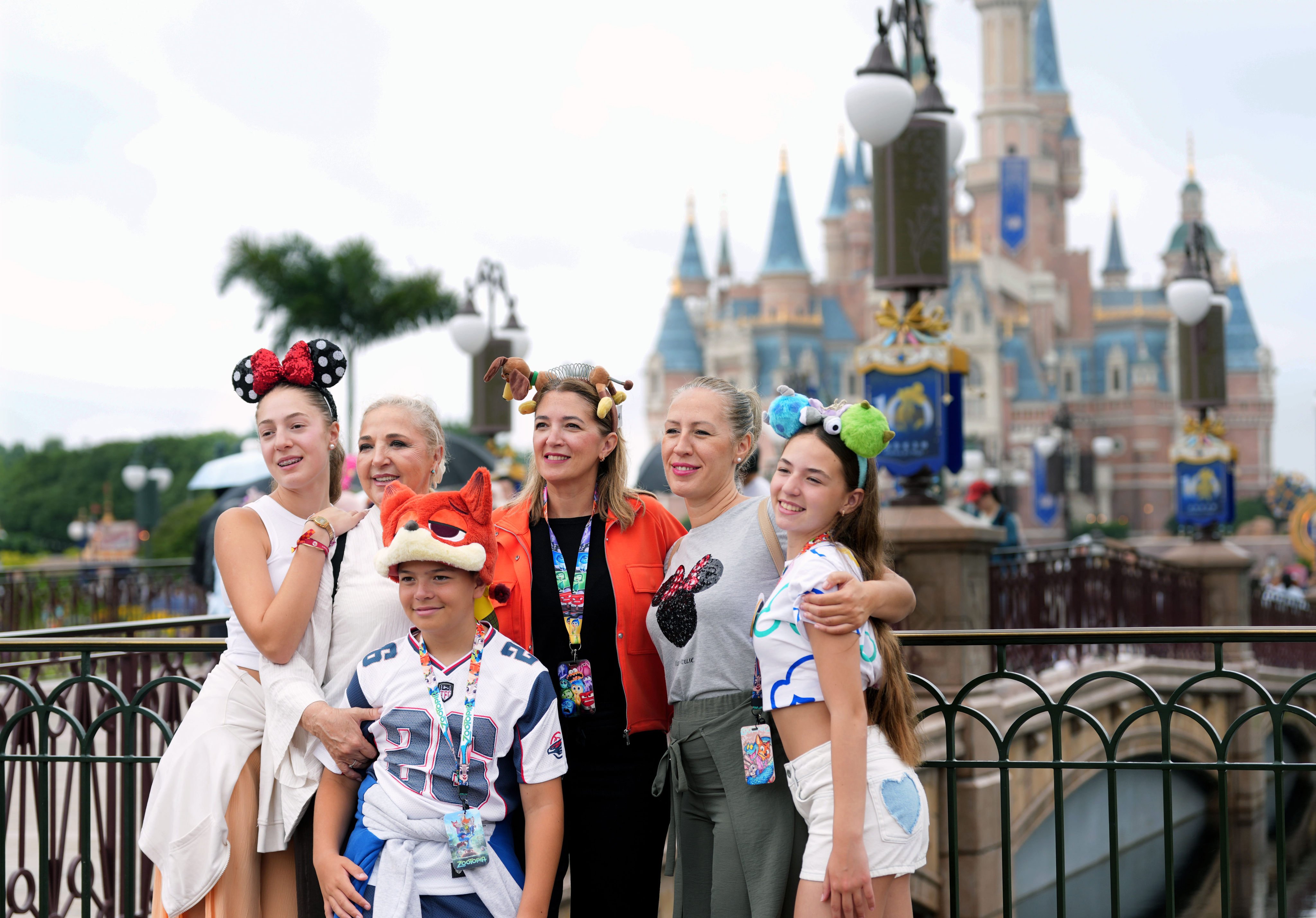 Tourists pose for a group photo at Shanghai Disneyland on June 16. Photo: Xinhua