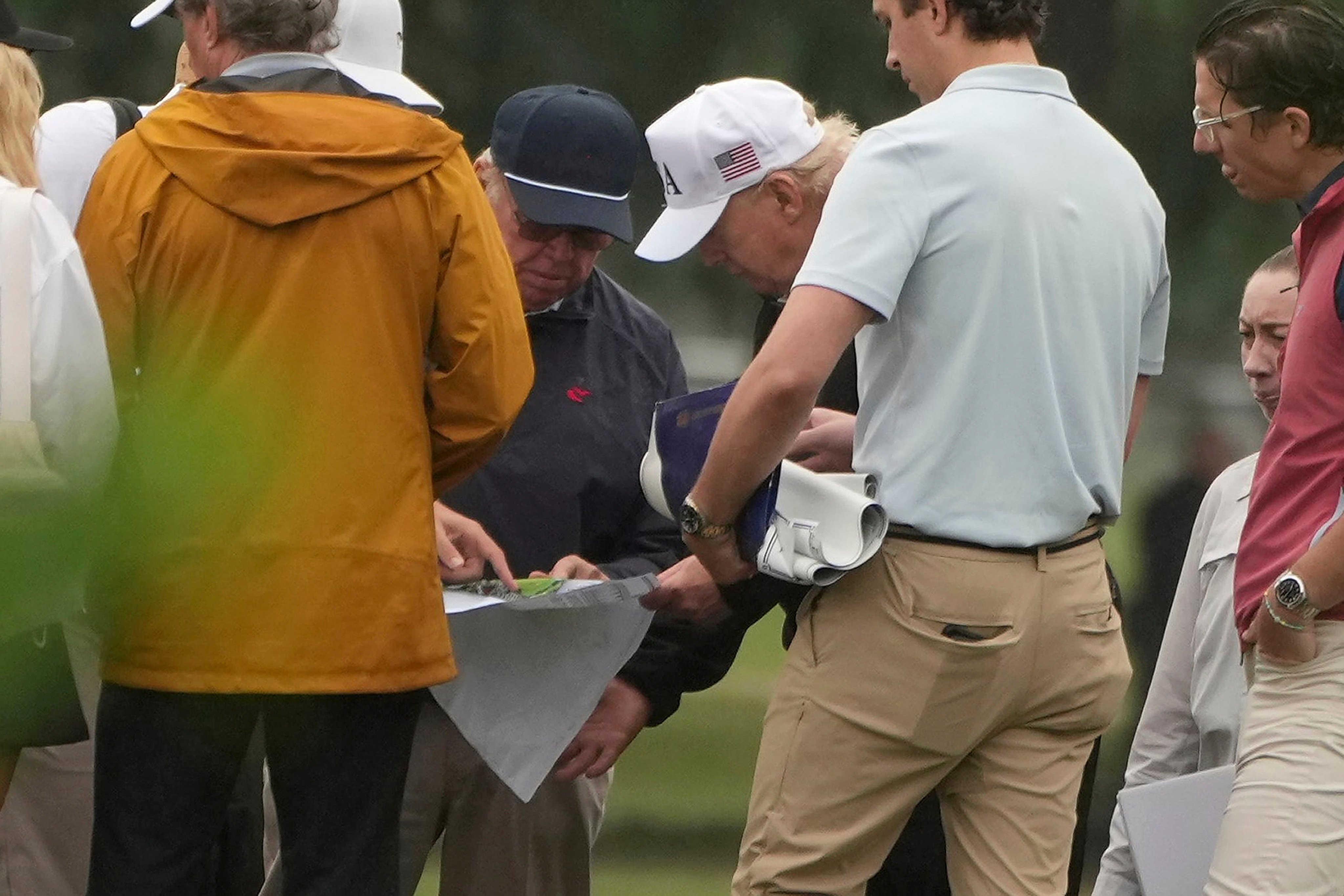 President Donald Trump looks at blueprints while touring the East Potomac Park golf course. Photo: AP