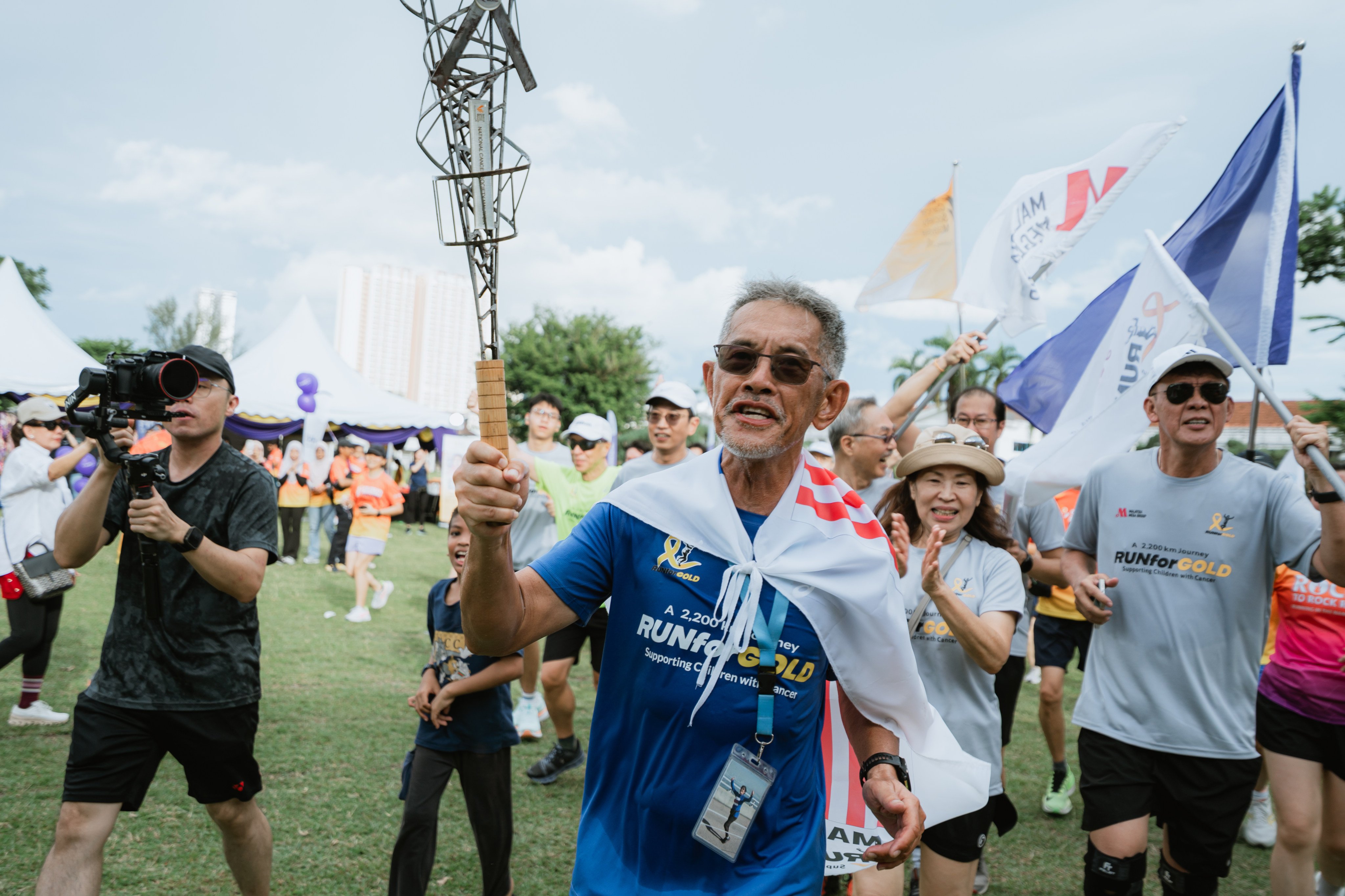 Lim Shyang Guey walks through a crowd after completing his “Run for Gold” campaign, in which he ran 2,200km around Peninsular Malaysia over 86 days in tribute to his wife, who died of gallbladder cancer in 2024. Photo: Michael Tanhy